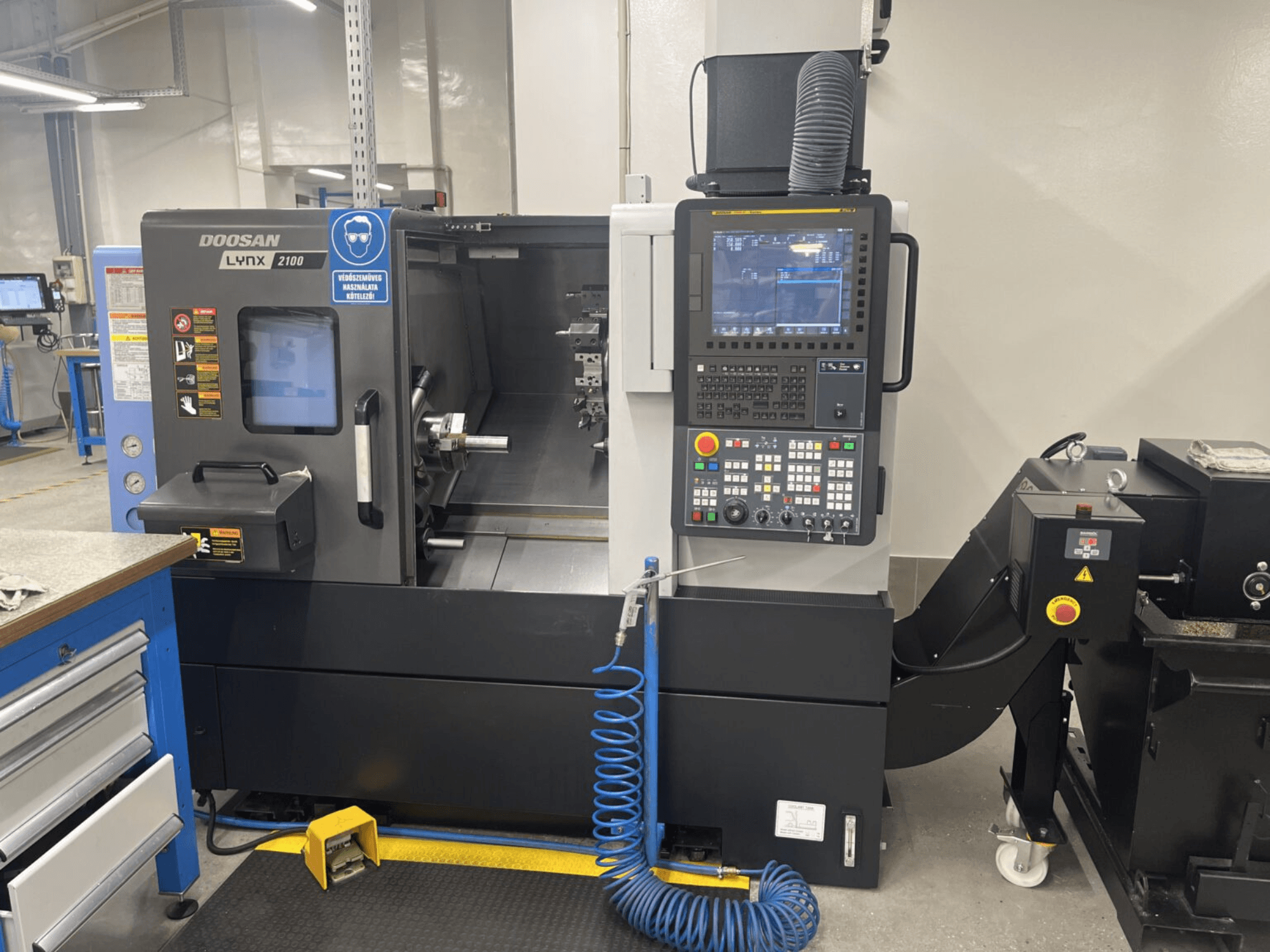 Vooraanzicht van een DOOSAN Lynx 2100A horizontale draaimachine, met het bedieningspaneel en het spindelgebied met opvallende veiligheidsvoorzieningen.