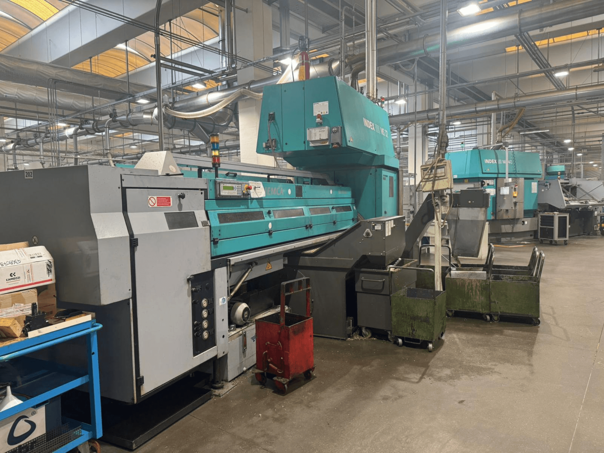 Meerassige draaimachine, INDEX MS32C, vooraanzicht met bedieningselementen en werkgebied in een werkplaats.