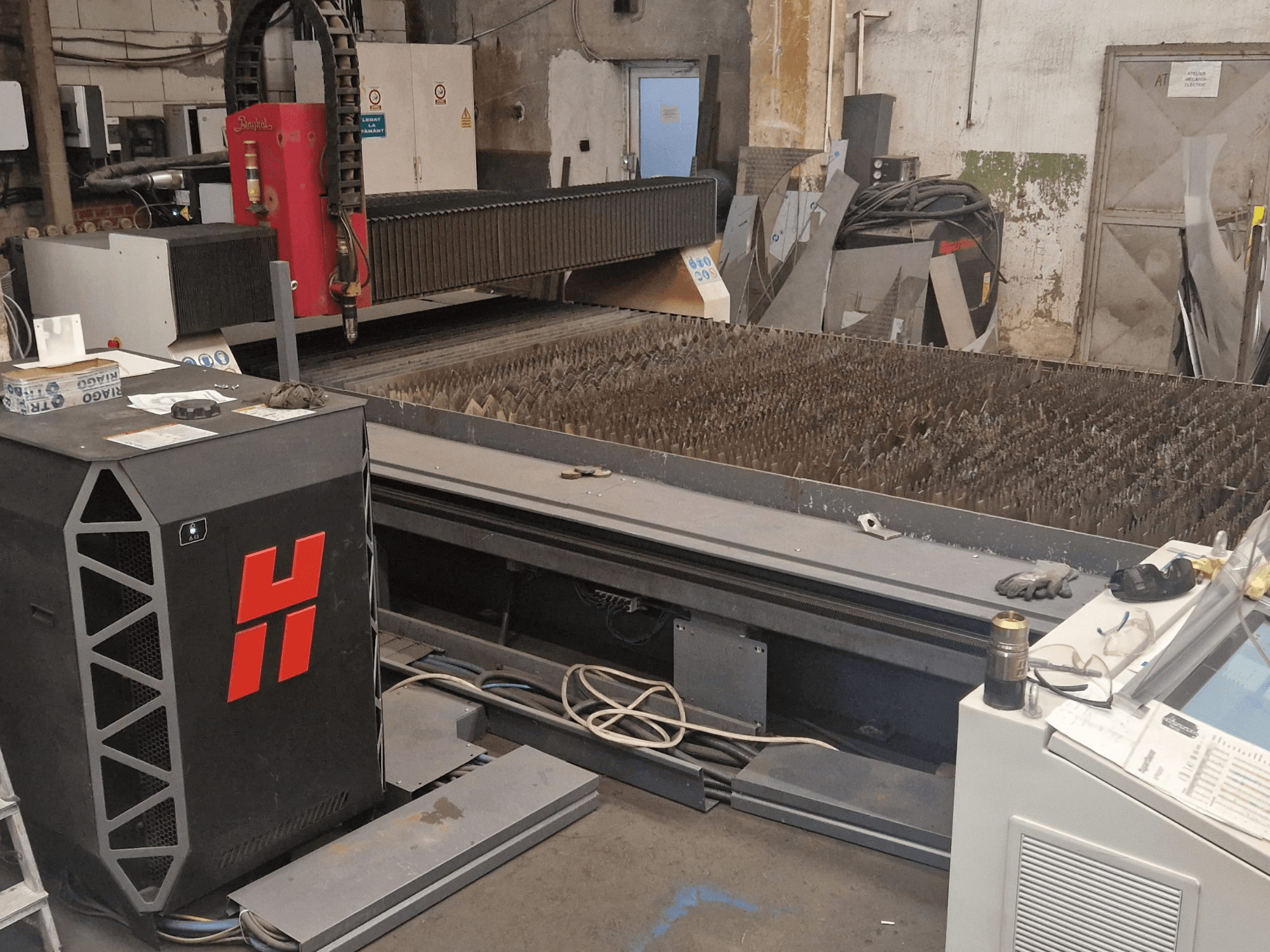 Baykal BPS 2004 plasmasnijmachine in een werkplaats, vooraanzicht met het snijbed en het bedieningspaneel.