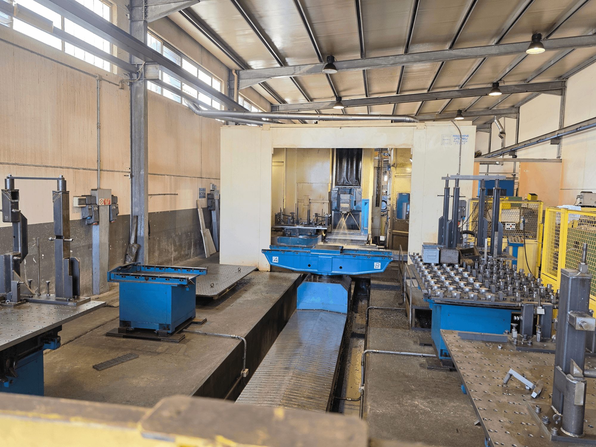Het horizontale bewerkingscentrum Mandelli RS1500U in een fabrieksomgeving, met daarin machines, gereedschappen en werkoppervlakken.