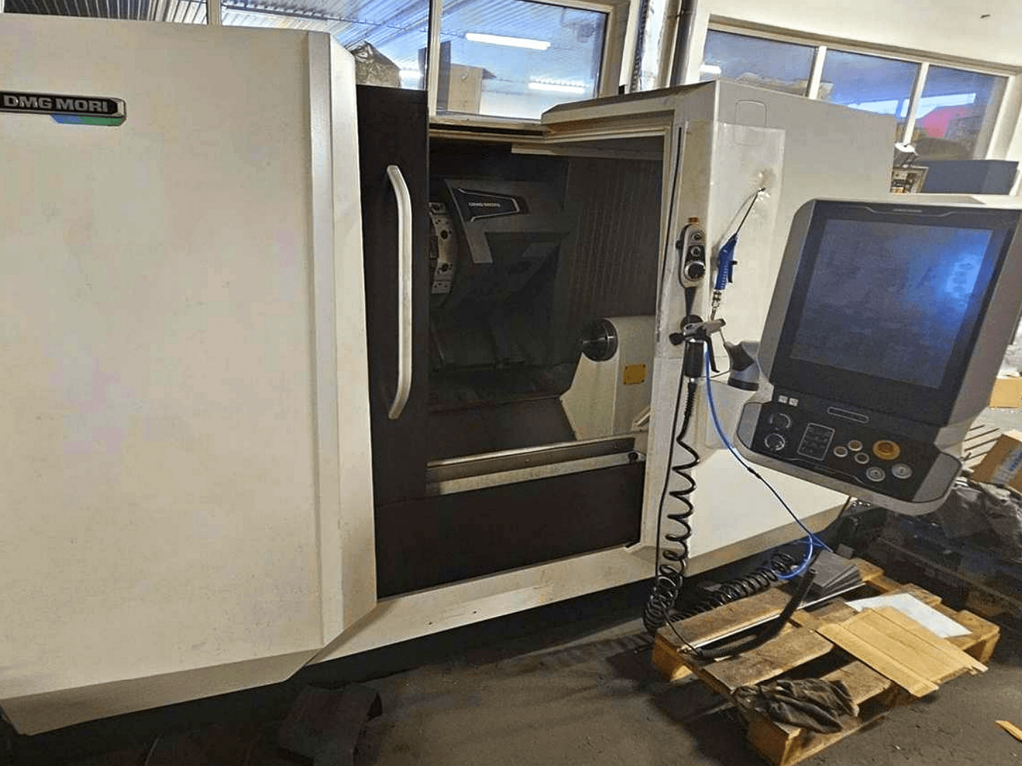 DMG MORI CLX 450 V4 horizontale draaimachine, vooraanzicht met bedieningspaneel, ter illustratie van de werkruimte en het ontwerp van de behuizing.