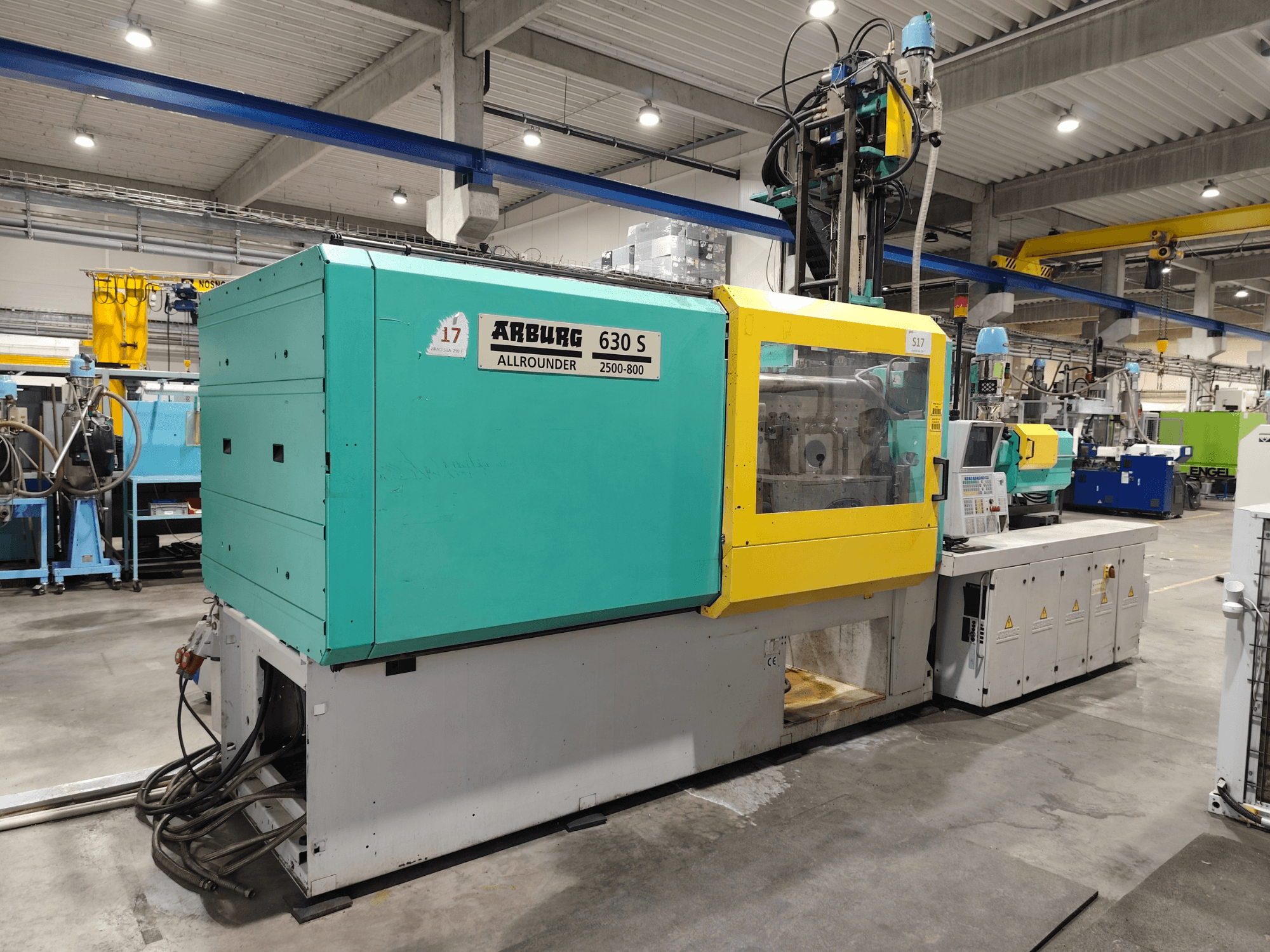 Arburg Allrounder 630S-2500-800/350 hydraulische spuitgietmachine, zijaanzicht, met kleurrijke behuizing en zichtbaar bedieningspaneel.