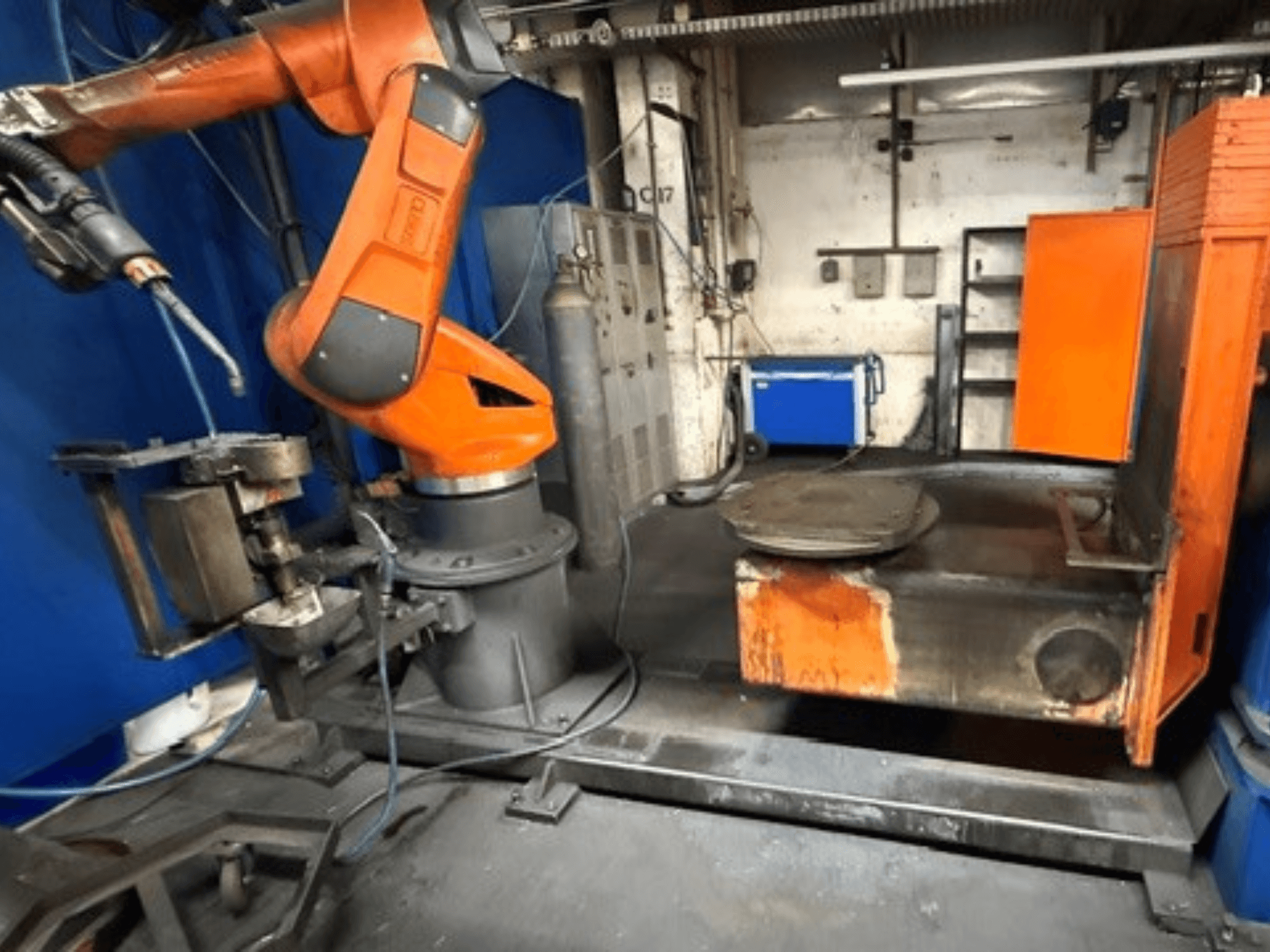 De CLOOS C50-lasrobot in vooraanzicht, met een oranje robotarm en een metalen werktafel.