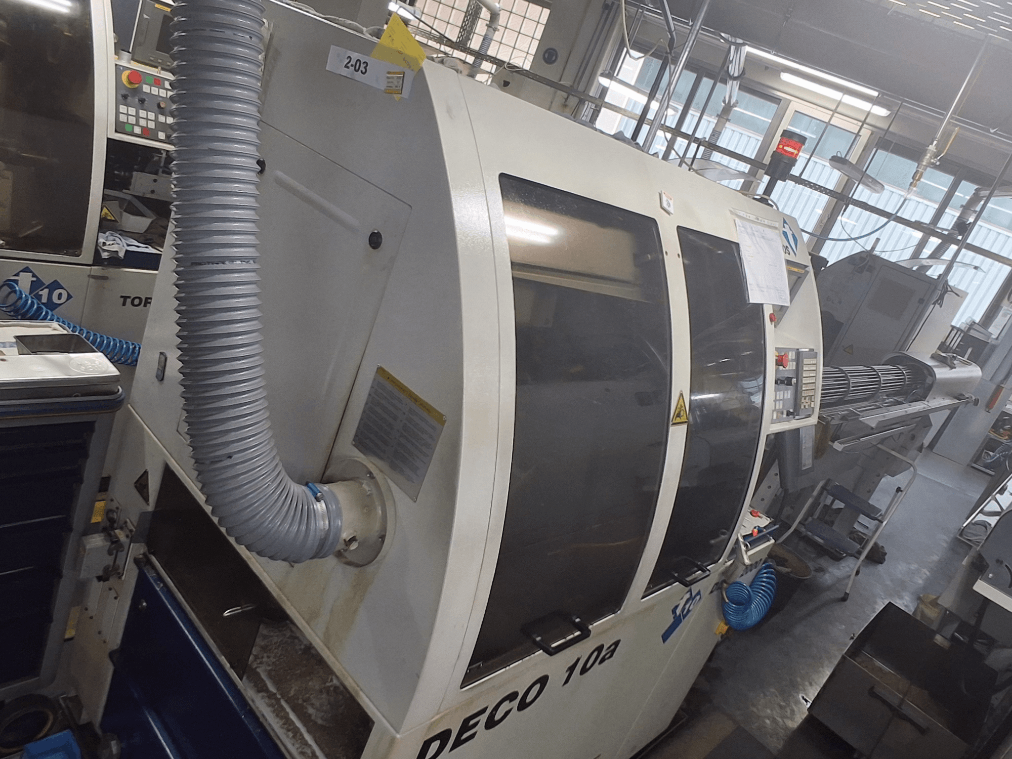 DECO 10a machine in vooraanzicht; het grote bedieningspaneel, de leidingen en de operationele stickers zijn zichtbaar.