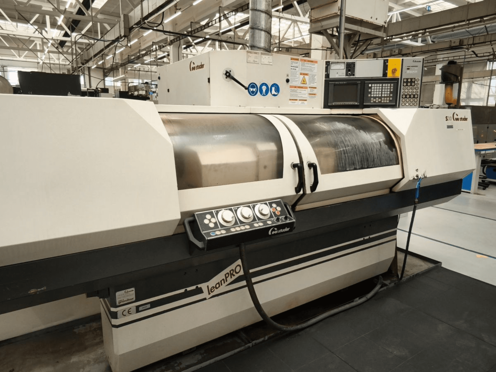 STUDER S30 LEAN PRO rondslijpmachine, zijaanzicht, met het bedieningspaneel en de slijpschijfafdekking in een industriële omgeving.