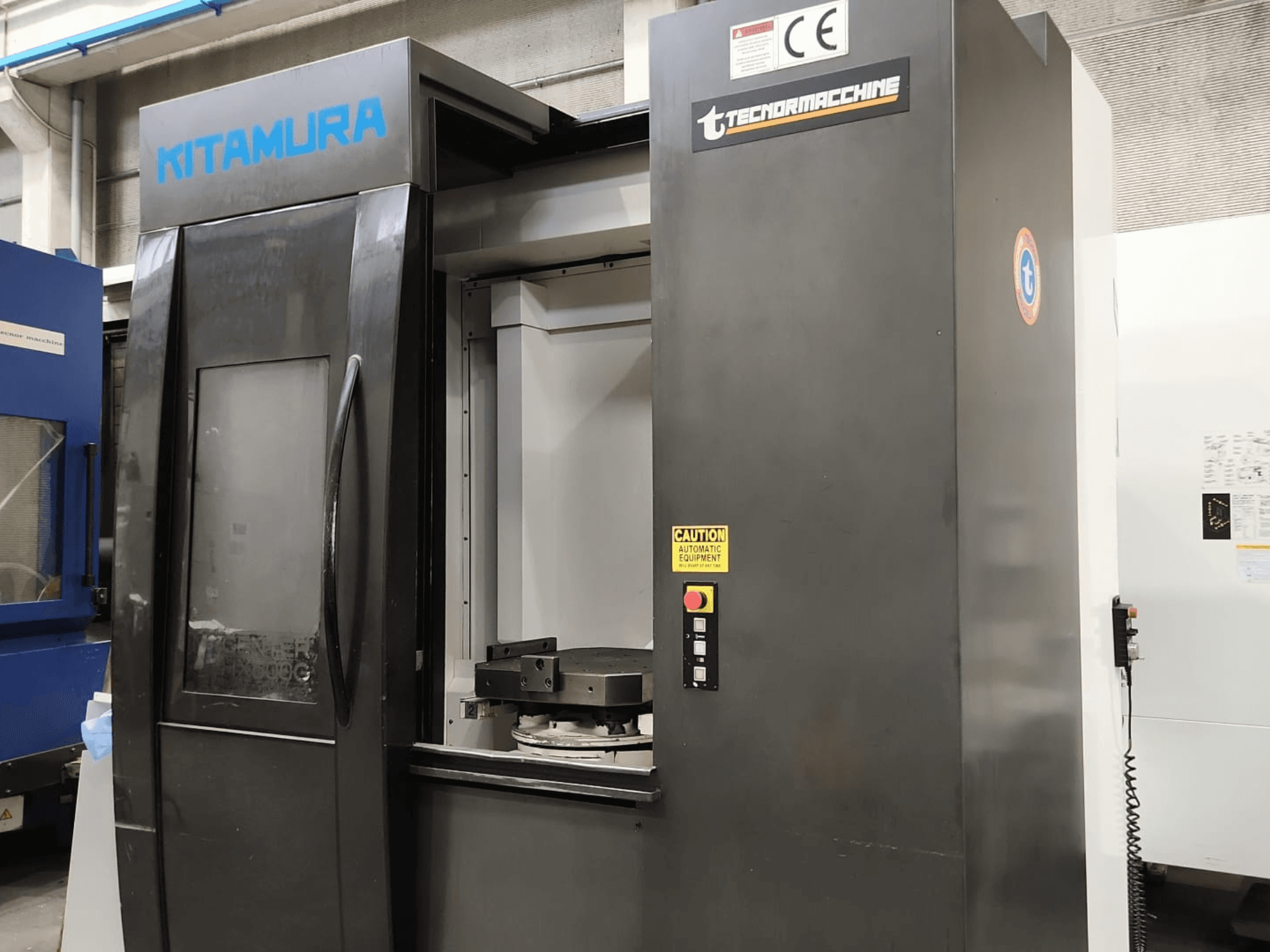 Horizontaal bewerkingscentrum Kitamura Mycenter HX500iG, vooraanzicht met het bedieningspaneel en het werkgebied.