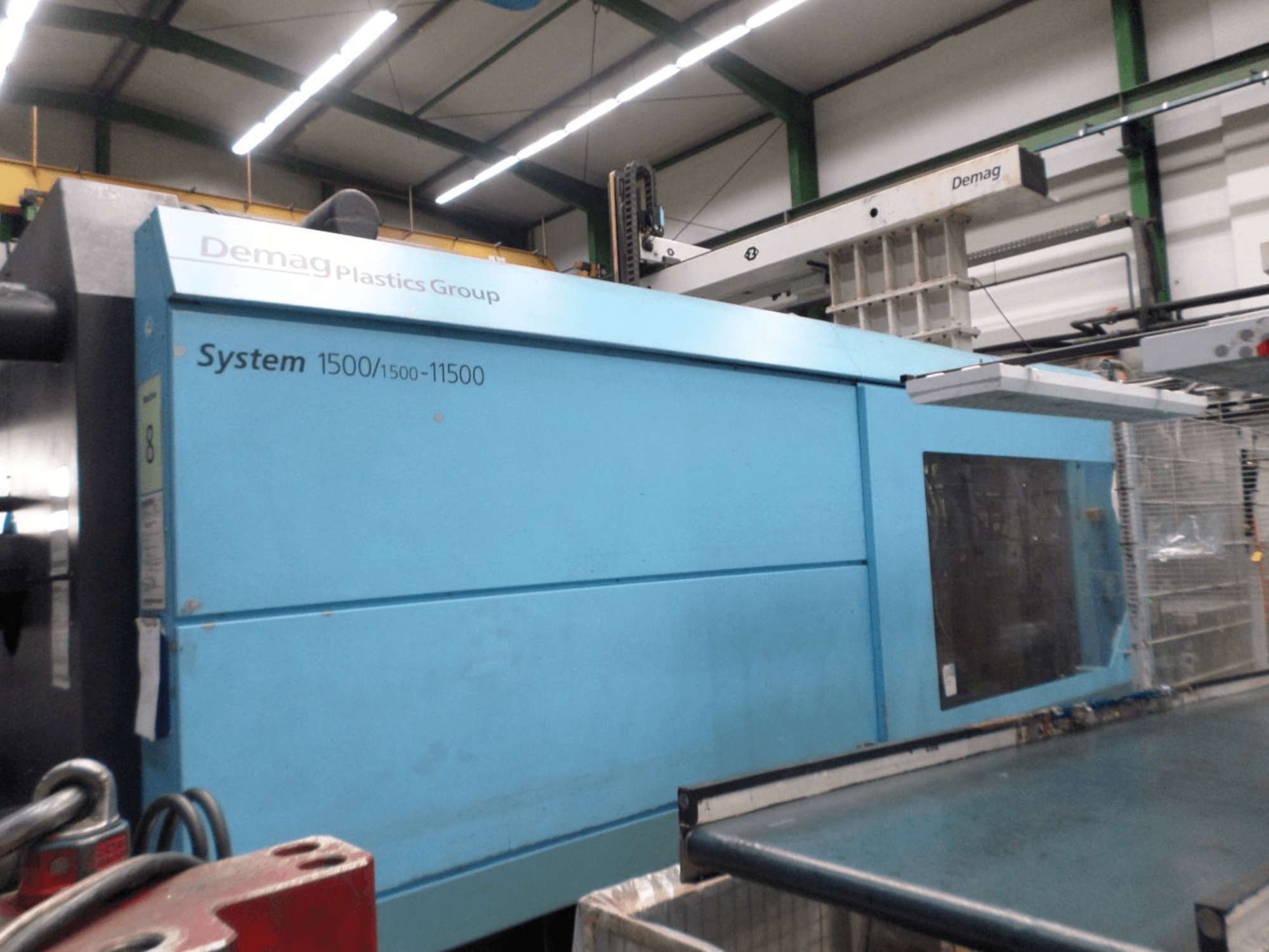 Demag D 650 hydraulische spuitgietmachine in het blauw, zijaanzicht met het opschrift ‘System 1500/1500-11500’ en het bedieningspaneel.