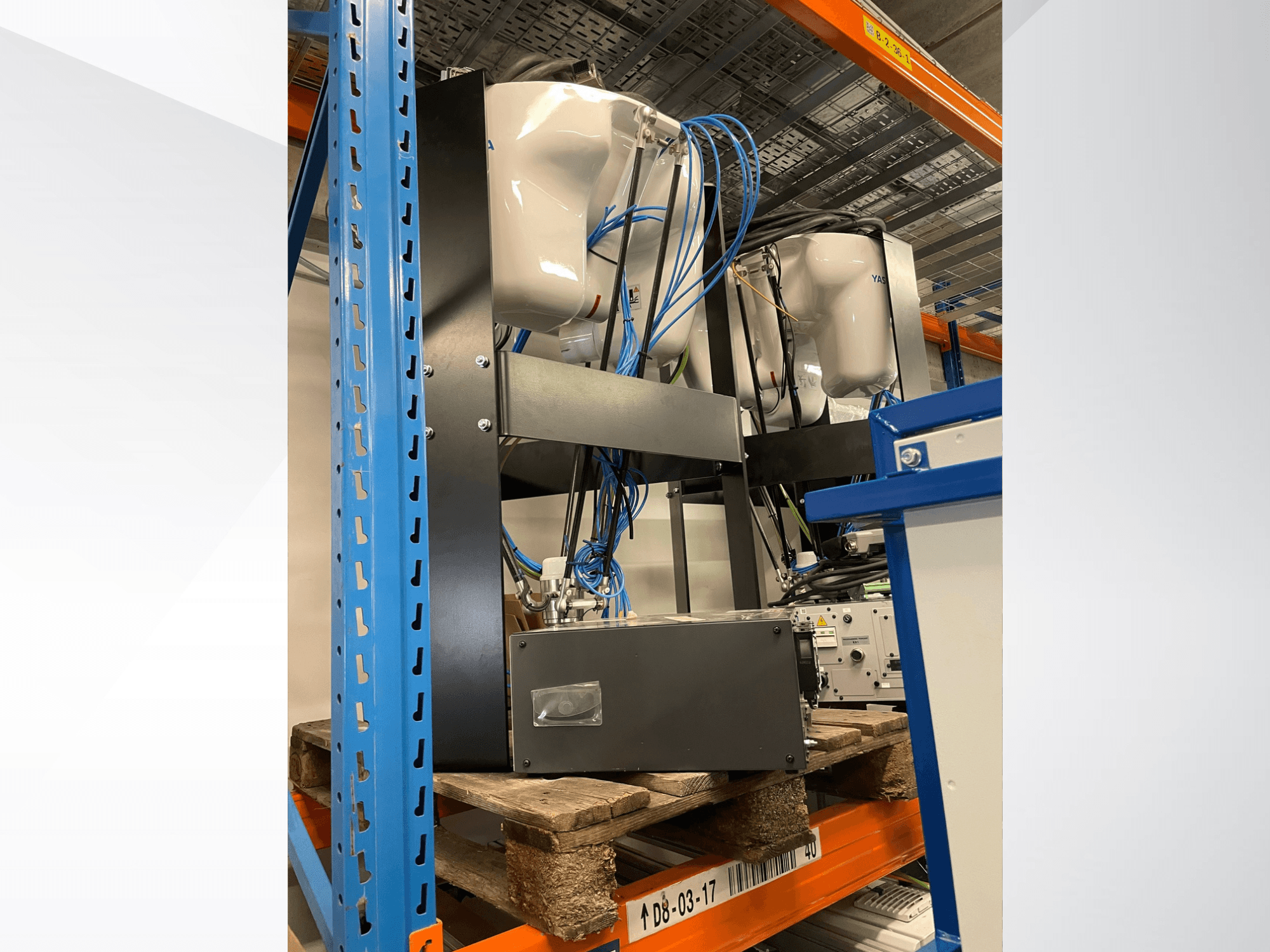 Yaskawa Motoman MPP3H-robotarm, weergegeven in zijaanzicht, met zichtbare bedrading en onderdelen op een opbergrek.
