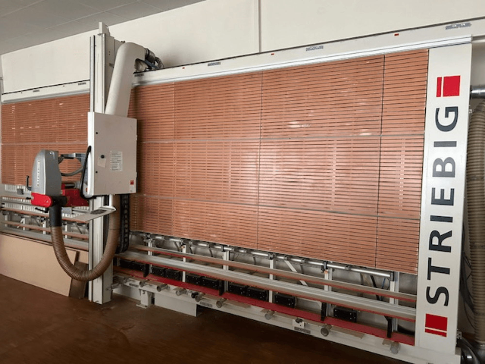 Striebig verticale paneelzaag in zijaanzicht, met een gemotoriseerde kop, zaagbladen voor houten panelen en stofafzuigsysteem.