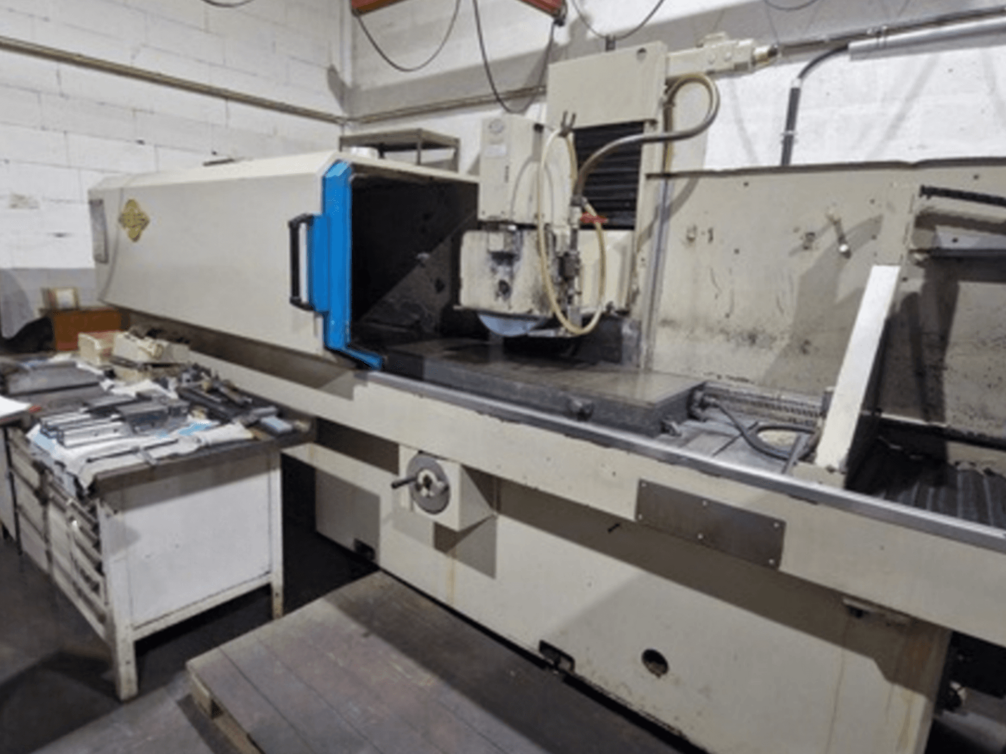 ELB vlakslijpmachine in een werkplaats; zijaanzicht van de slijptafel en bedieningselementen, met gereedschap in de buurt.