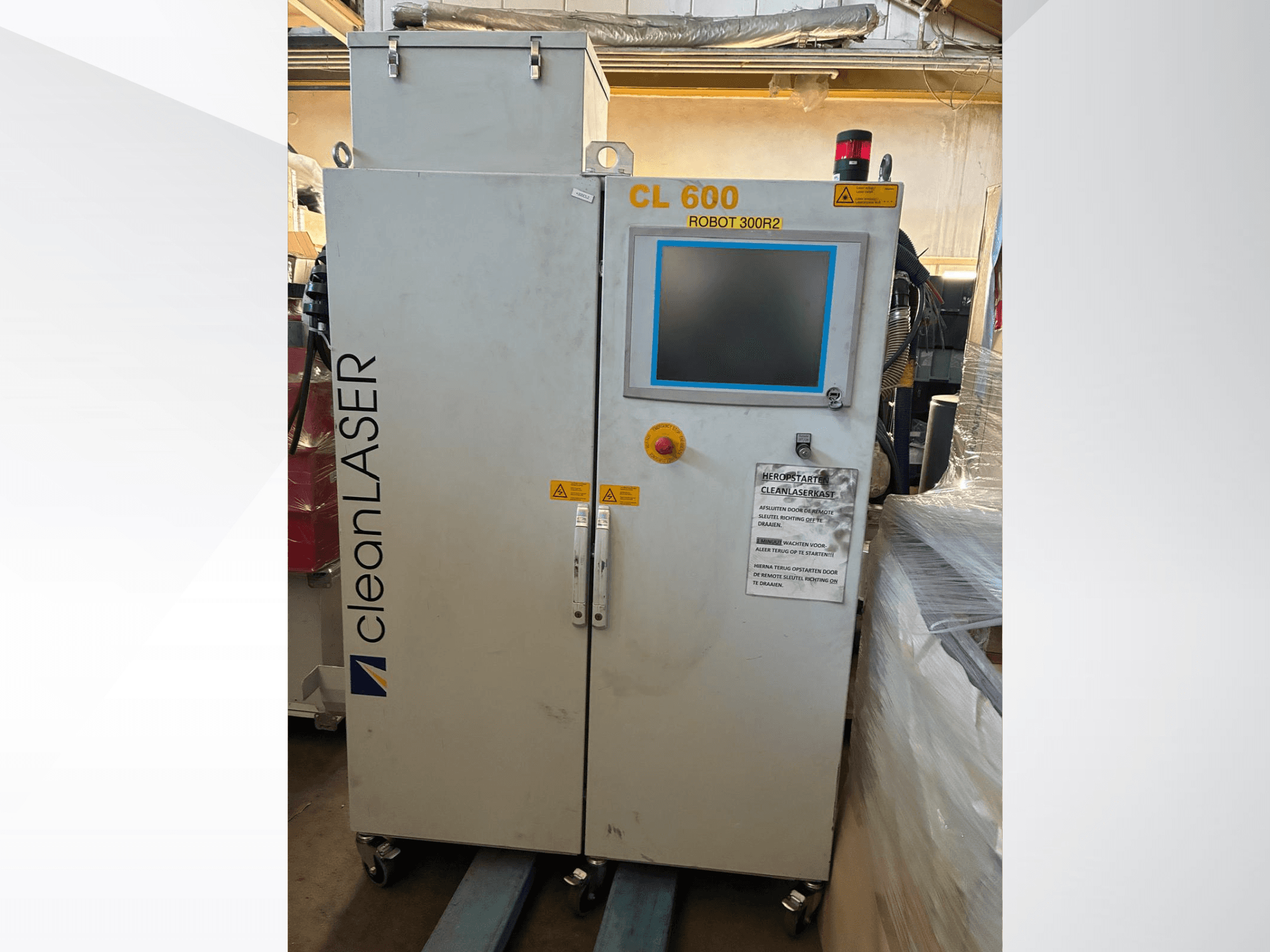 Het CLEAN LASER CL 600-automatiseringssysteem in vooraanzicht, met LCD-scherm, waarschuwingslabels en bedieningsknoppen op de deur.