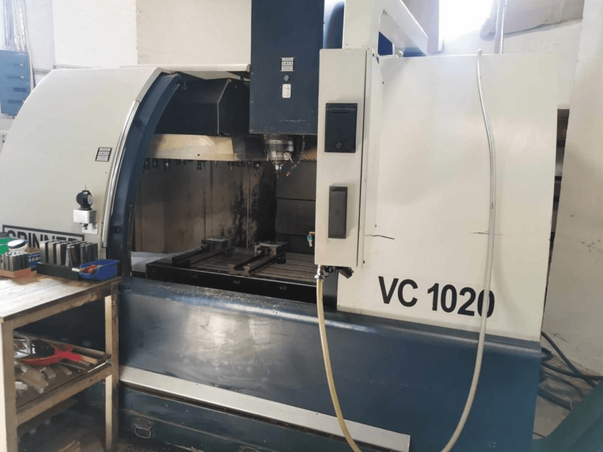 Verticaal bewerkingscentrum SPINNER VC 1020 in vooraanzicht, met weergave van het werkgebied en de bedieningselementen aan de zijkant.