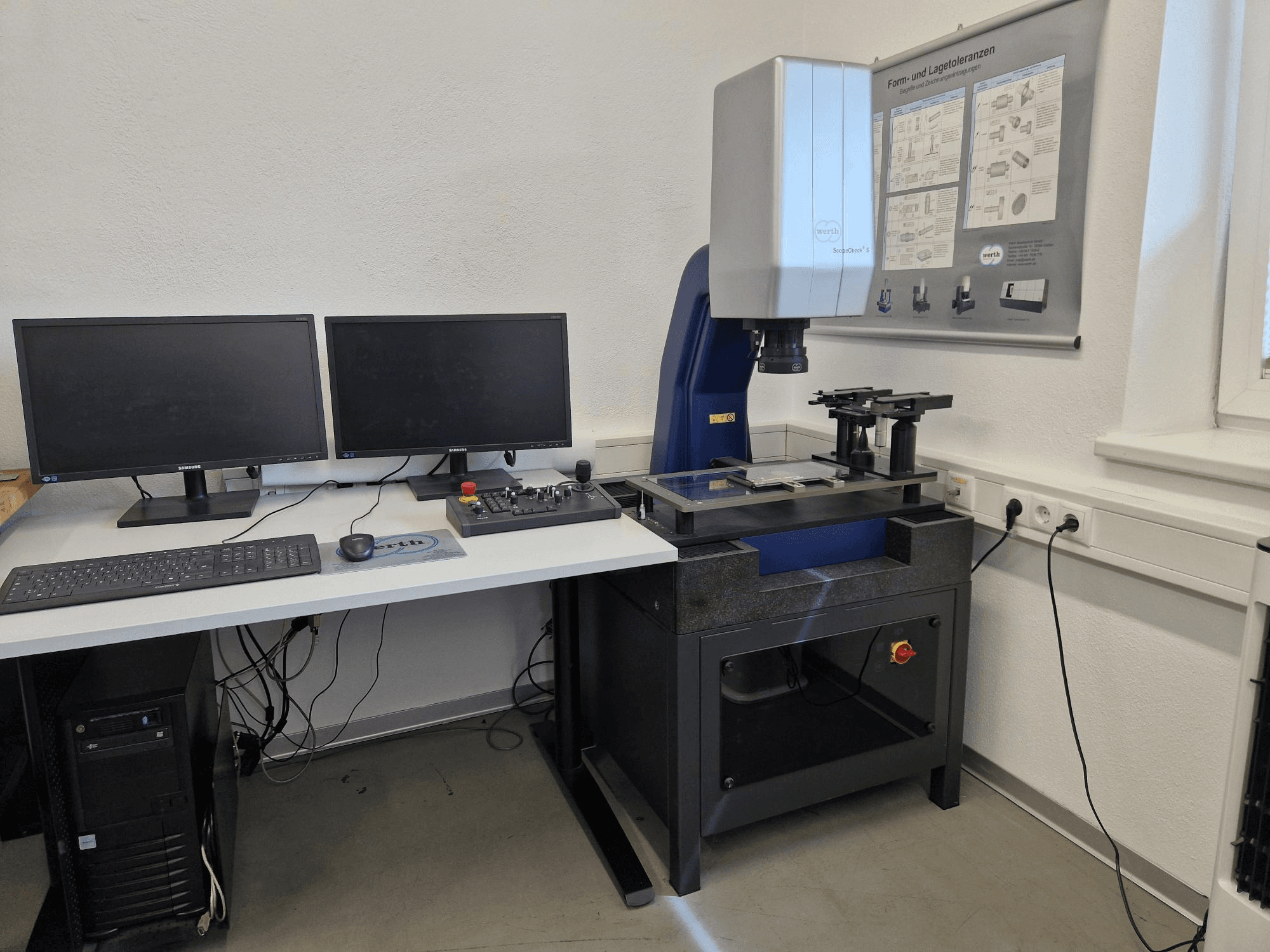 Werth Scopecheck 300S CMM in een laboratoriumopstelling; omvat een meettafel, twee monitoren en een bedieningspaneel.