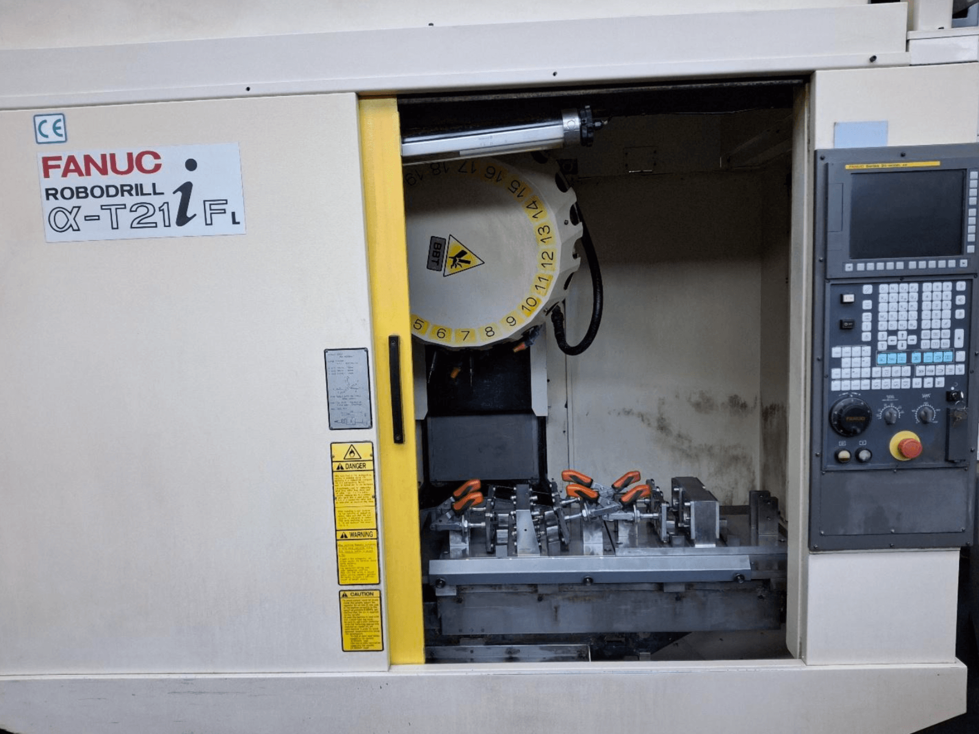 FANUC ROBODRILL α-T21iFL verticaal bewerkingscentrum vooraanzicht, met gereedschap en bedieningselementen in de machinekast.