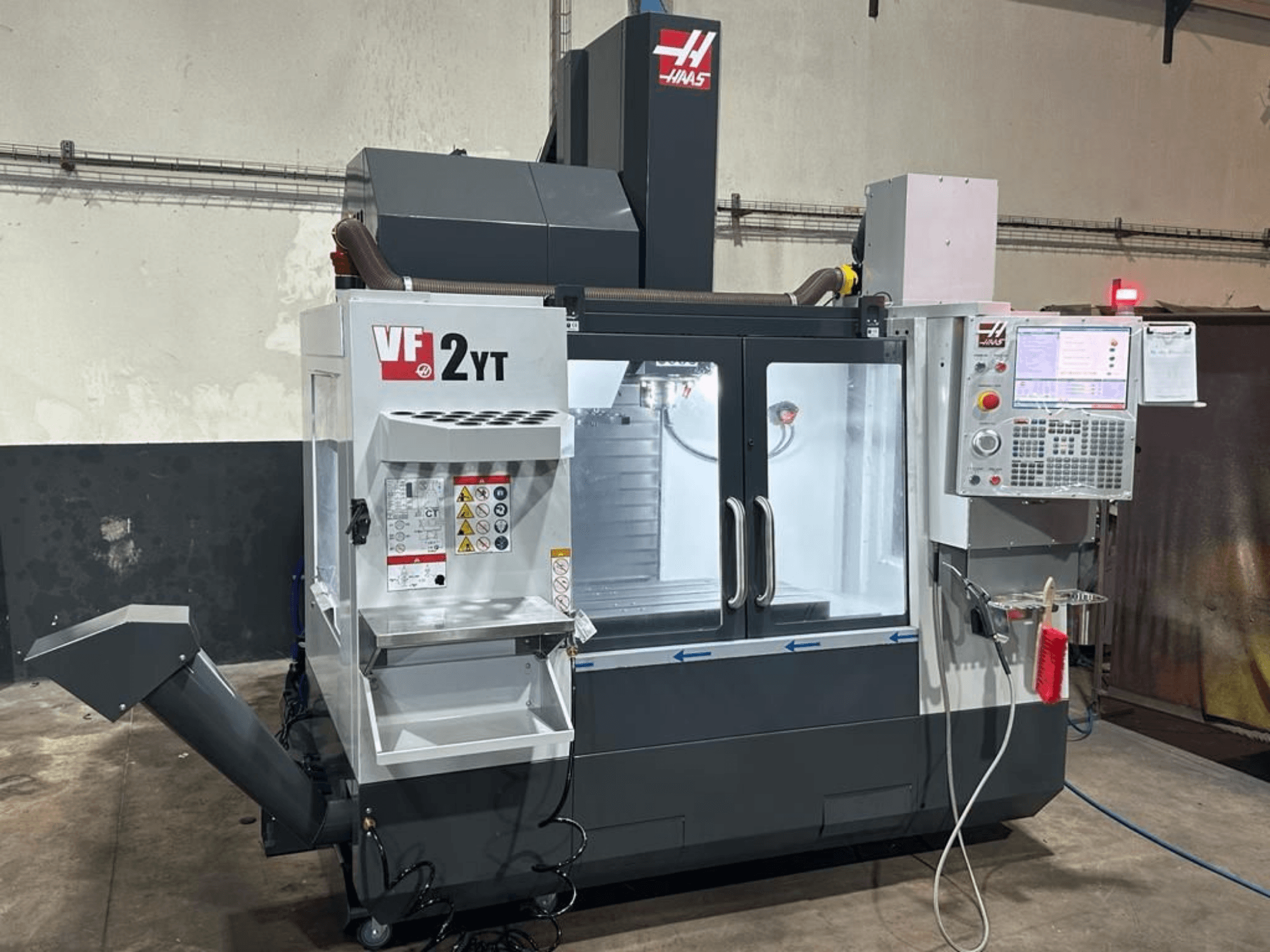 Verticaal bewerkingscentrum HAAS VF-2YT-EU in vooraanzicht, met het bedieningspaneel en het gereedschapskastje.