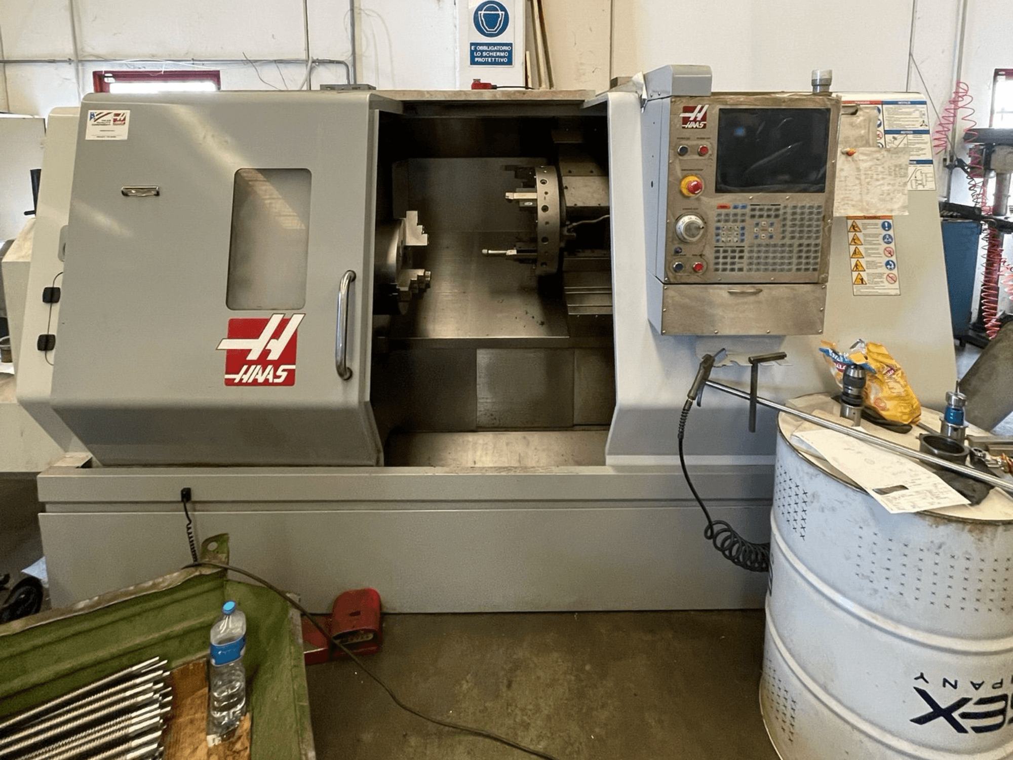 HAAS SL-30TBHE horizontale draaimachine in vooraanzicht, met bedieningspaneel, grote laaddeur en diverse gereedschappen in de buurt.