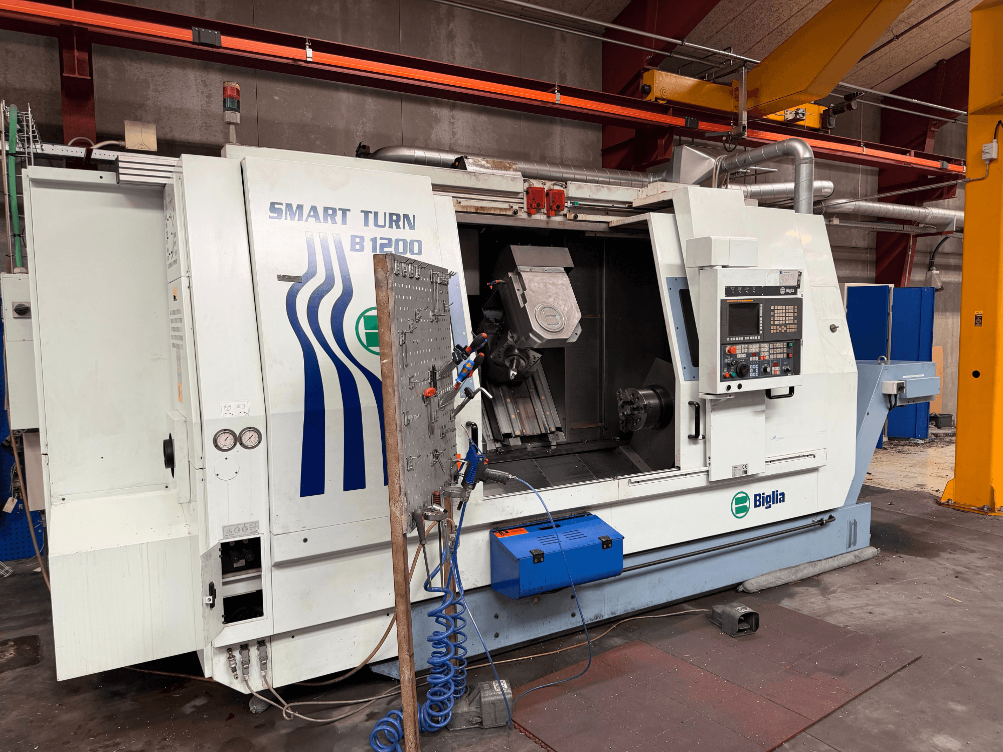 Biglia B.1200/S-Smart draai-freescentrum in vooraanzicht; met bedieningselementen, een werkstuk in de spil en manometers.