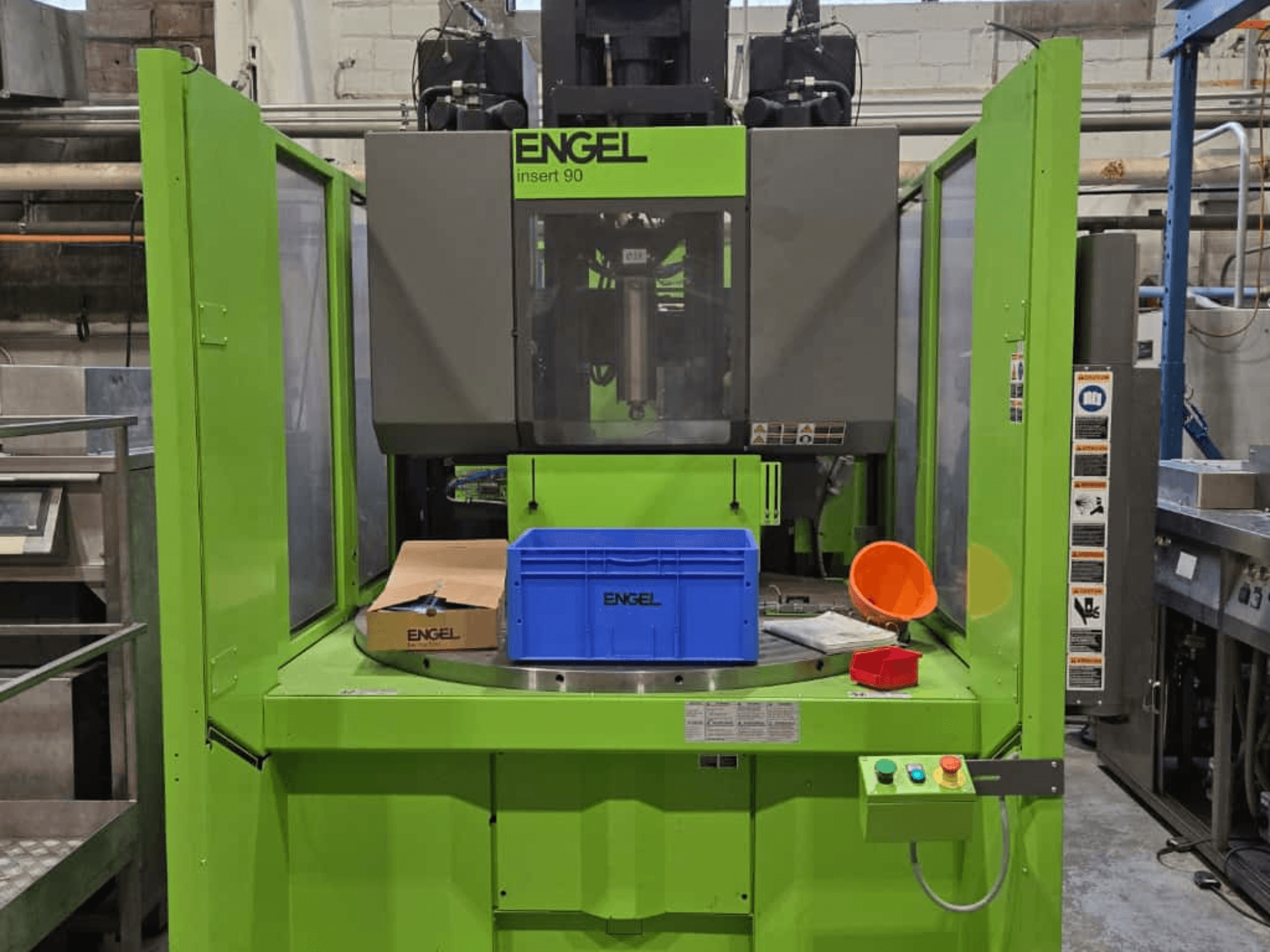 Groen ENGEL Insert 90 spuitgietmachine vooraanzicht, met blauwe container en bedieningspaneel met knoppen.