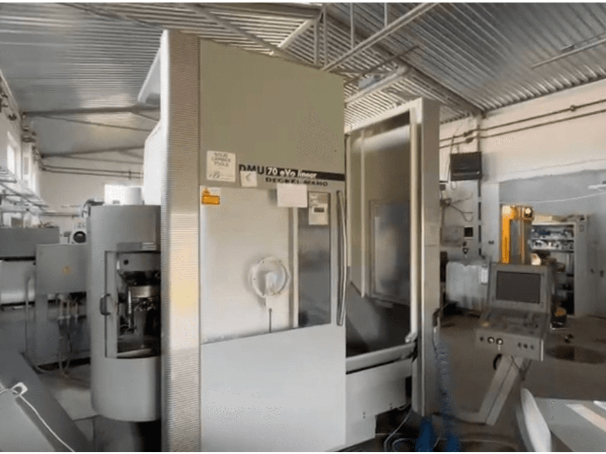 DMU 70 eVo lineaire CNC machine in een werkplaats, vooraanzicht, met een bedieningspaneel en een modern ontwerp.