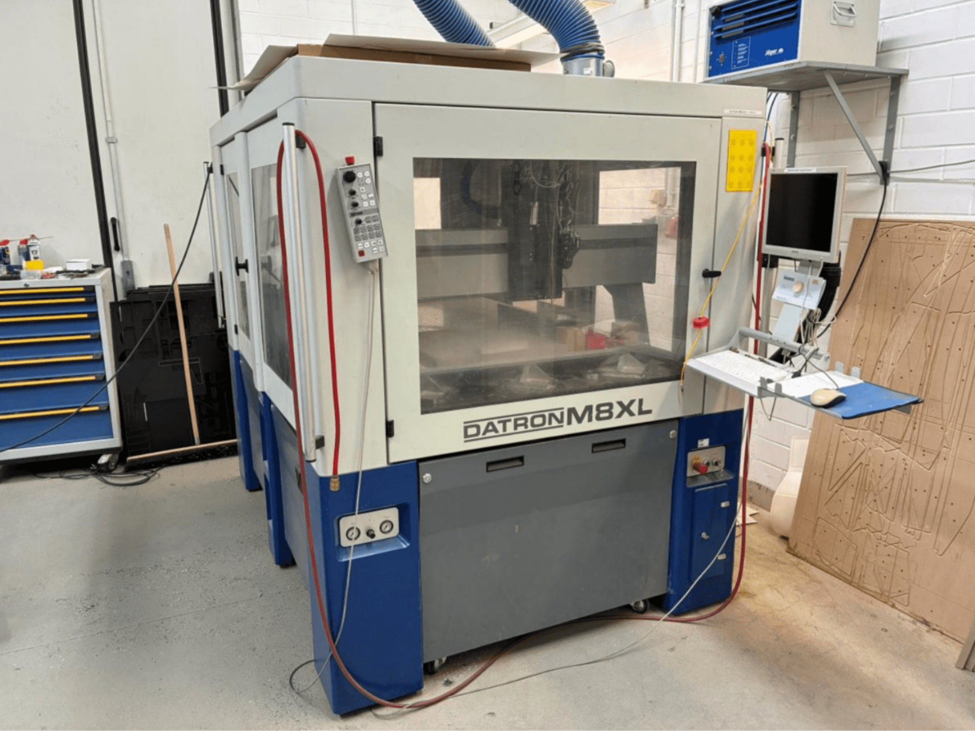 DATRON M8XL CNC machine in een werkplaats, vooraanzicht met bedieningspaneel en monitor ernaast gemonteerd.
