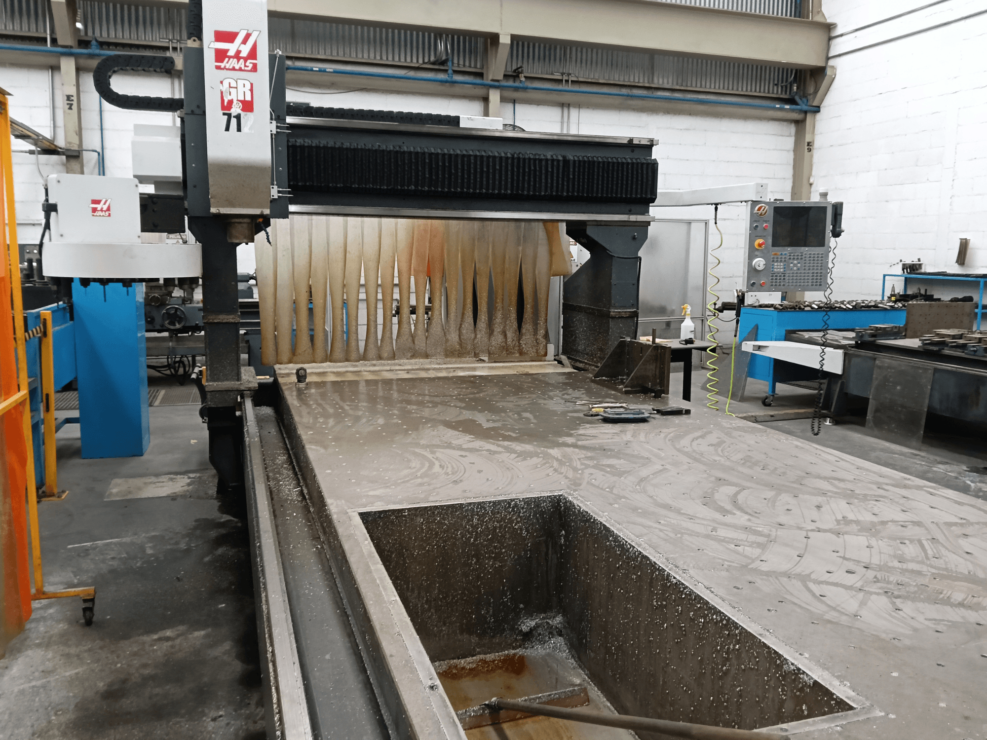 HAAS GR-712 portaalfreesmachine, gezien vanaf de voorkant, met een nat snijvlak en het bedieningspaneel.
