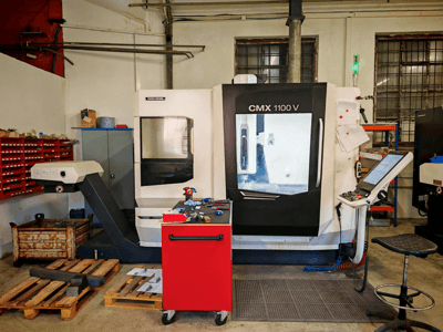 Verticaal bewerkingscentrum DMG MORI CMX 1100 V in de werkplaats, vooraanzicht, met het bedieningspaneel en de omliggende gereedschappen.
