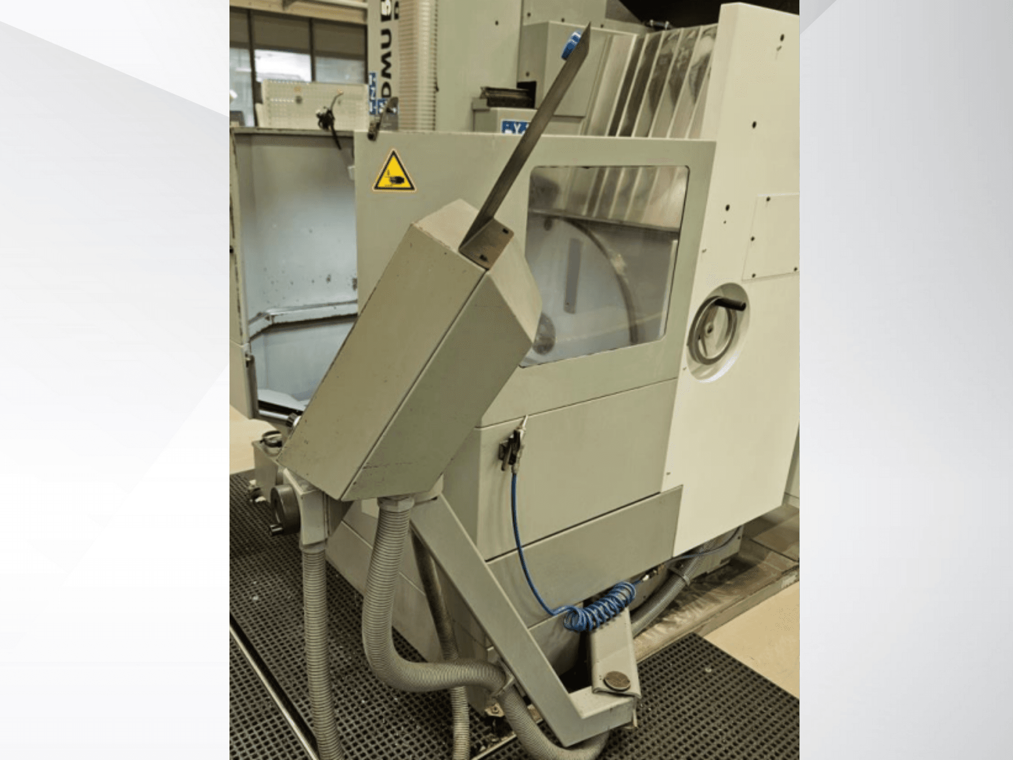 Zijaanzicht DMU freesmachine met koelmondstuk en geïntegreerd bedieningspaneel; voorzien van veiligheidswaarschuwingslabel.