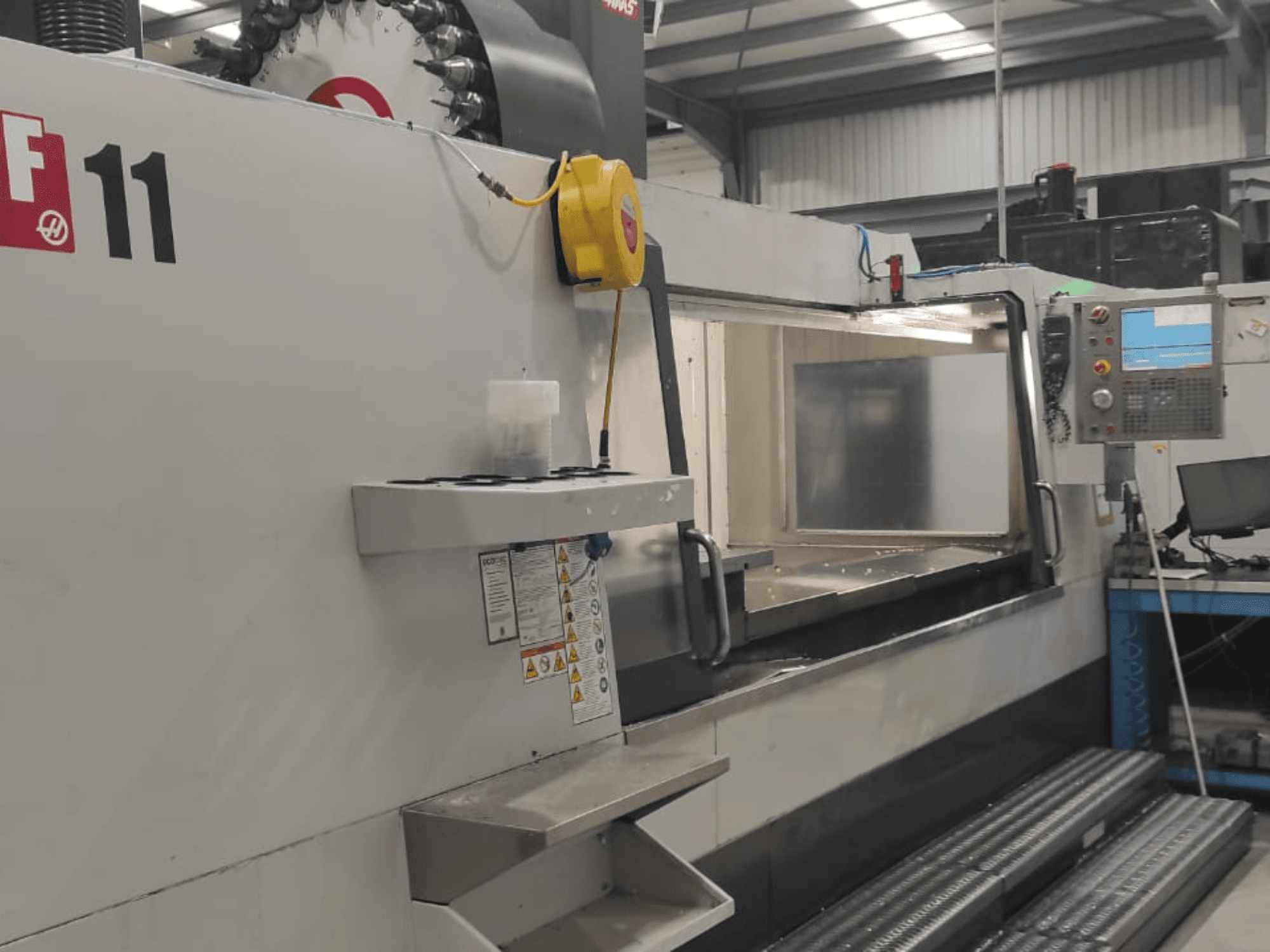 Machine van Haas, model VF-11, vooraanzicht met bedieningspaneel, groot werkgebied en veiligheidslabels zichtbaar.