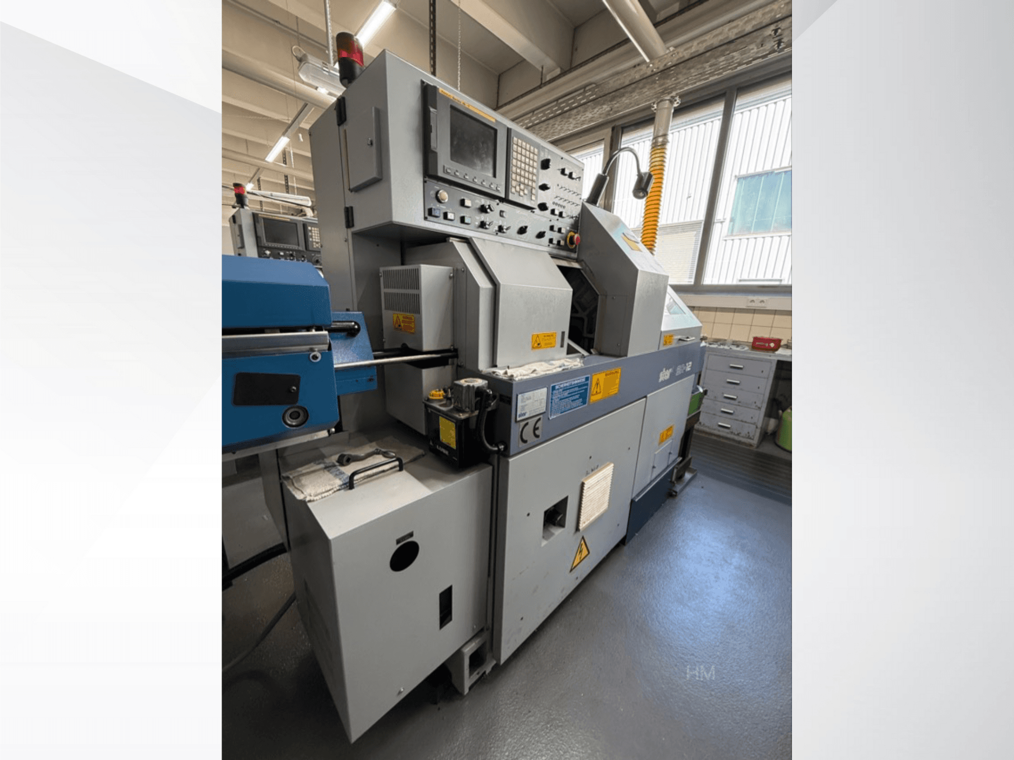 Vooraanzicht van de lithec 3231 machine, met het bedieningspaneel, de motor en het blauwe invoergedeelte in een goed verlichte industriële omgeving.