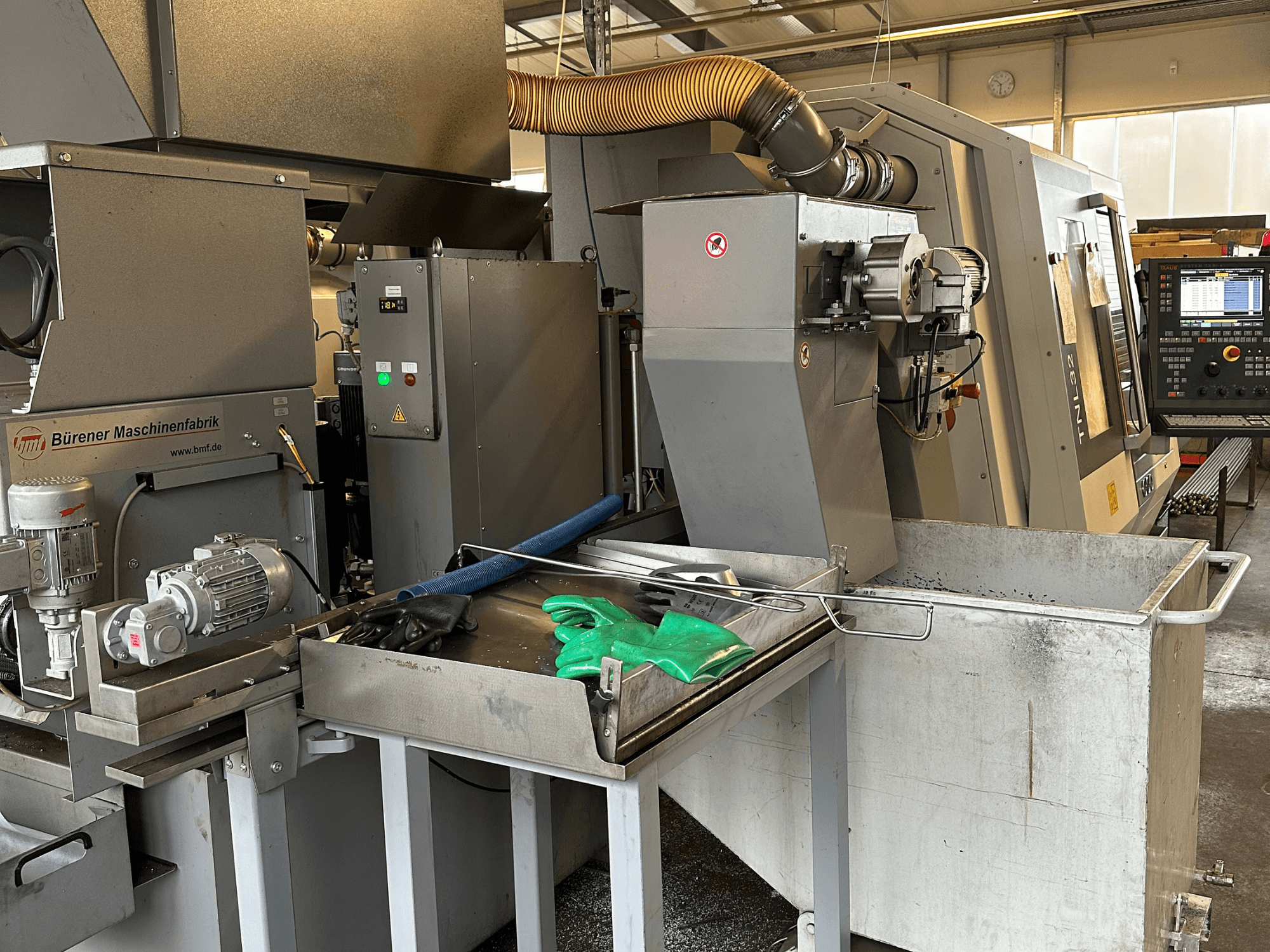 TRAUB TNL32-9 Zwitserse draaimachine, zijaanzicht, met het bedieningspaneel, de motor en het snijgedeelte met metaalspanen.