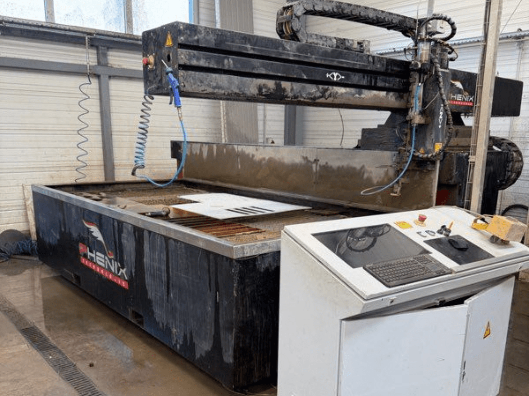 PHENIX MD JET 1530 waterstraalsnijmachine, vooraanzicht met bedieningspaneel en snijgedeelte met zichtbare watertank.