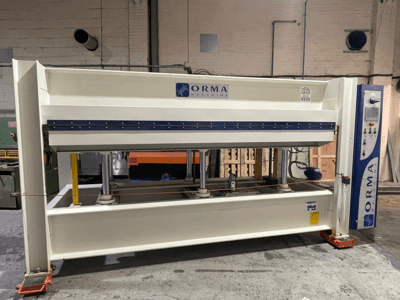 Hydraulische pers van ORMA machines, vooraanzicht, met zilveren afwerking, bedieningspaneel rechts, en rechtopstaande zuigers om te persen.