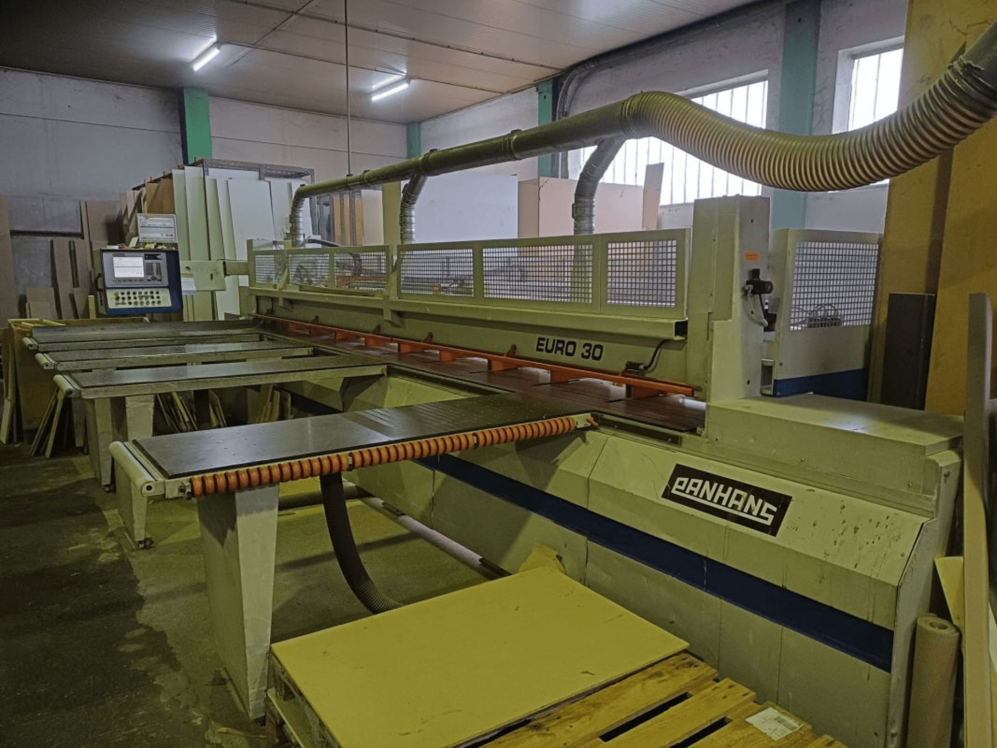 Vooraanzicht van PANHANS EURO 30 paneelzaag met bedieningspaneel, zaagtafel en stofafzuigslang in een werkplaats.