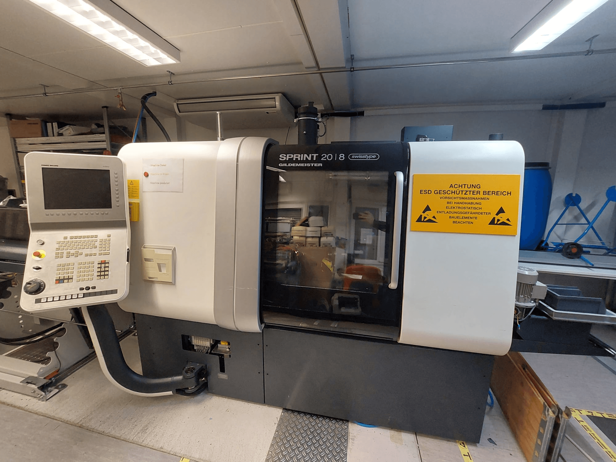 Vooraanzicht van DMG MORI Gildemeister Sprint 20/8 lineair; Zwitserse draaimachine met bedieningspaneel en veiligheidsbord.