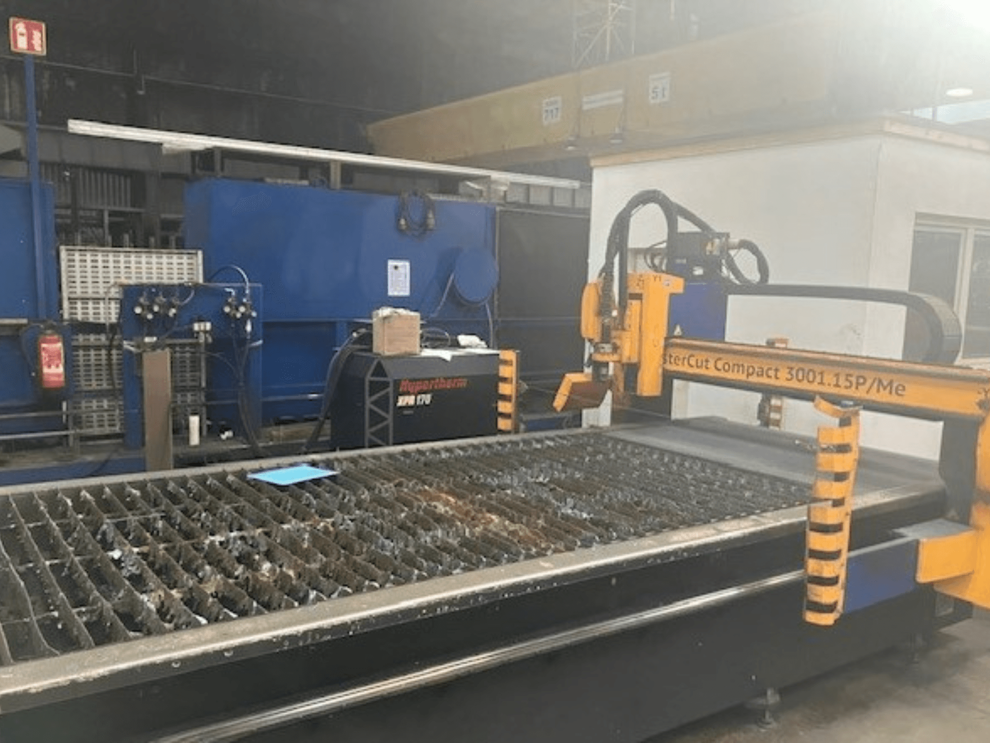 Hypertherm MasterCut Compact 3001.15P/Me plasmasnijmachine in zijaanzicht, met snijtafel en bedieningspaneel.