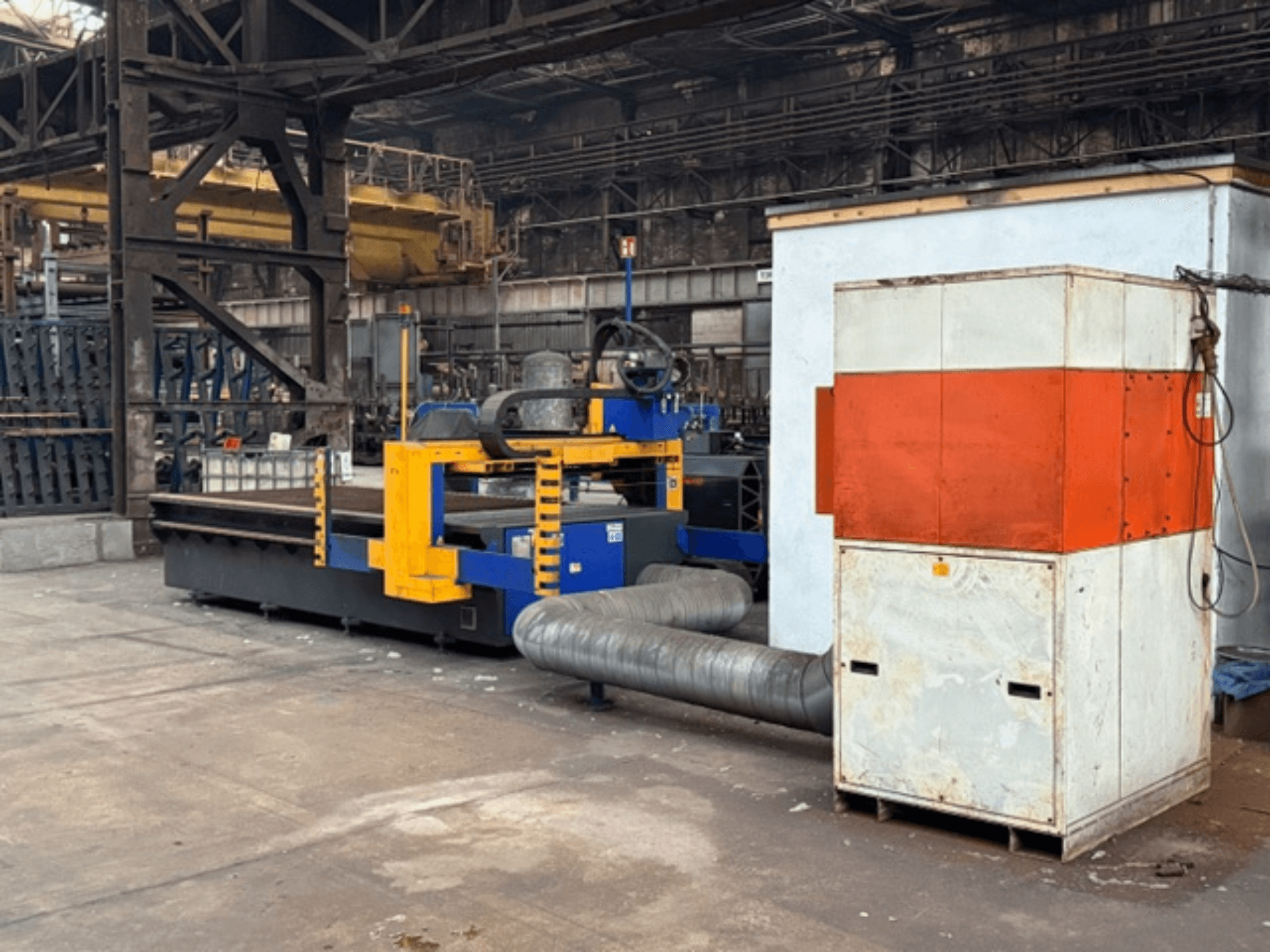 MicroStep 3001.15P/ME plasmasnijmachine in een fabrieksomgeving, zijaanzicht, met gele en blauwe onderdelen en een aangesloten uitlaatsysteem.