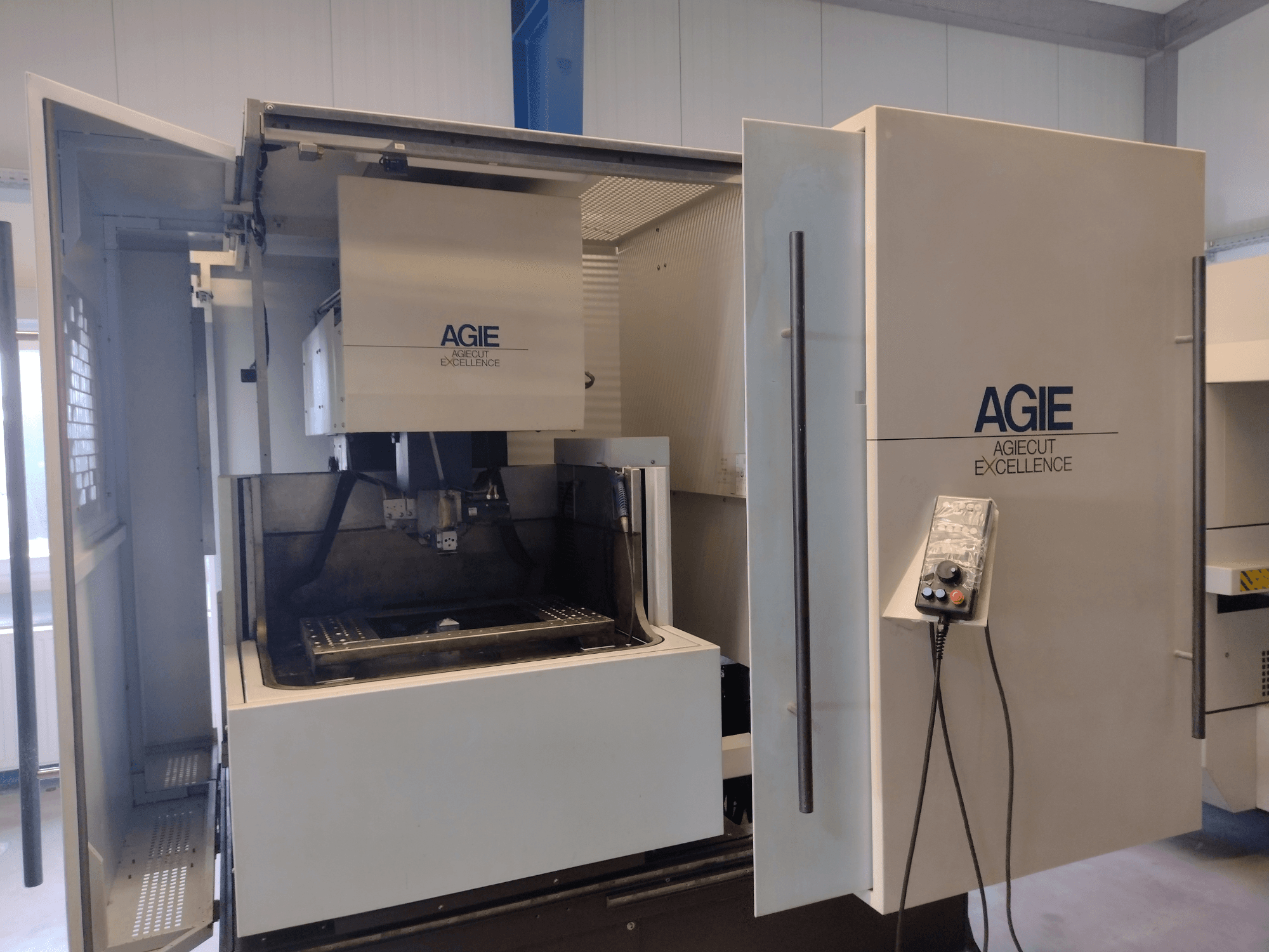 AGIE Progress 3-draads vonkmachine in vooraanzicht, met een open behuizing, bedieningspaneel en snijgebied.