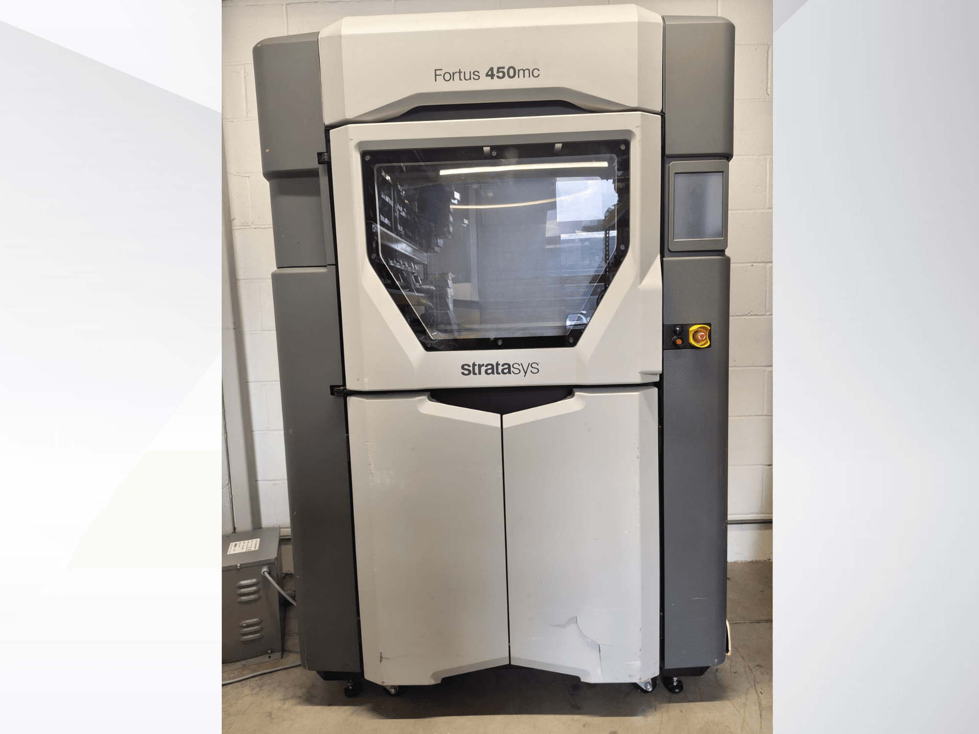 Stratasys Fortus 450mc kunststofverwerkingsmachine, vooraanzicht, met een groot venster, bedieningspaneel en een industrieel ontwerp.