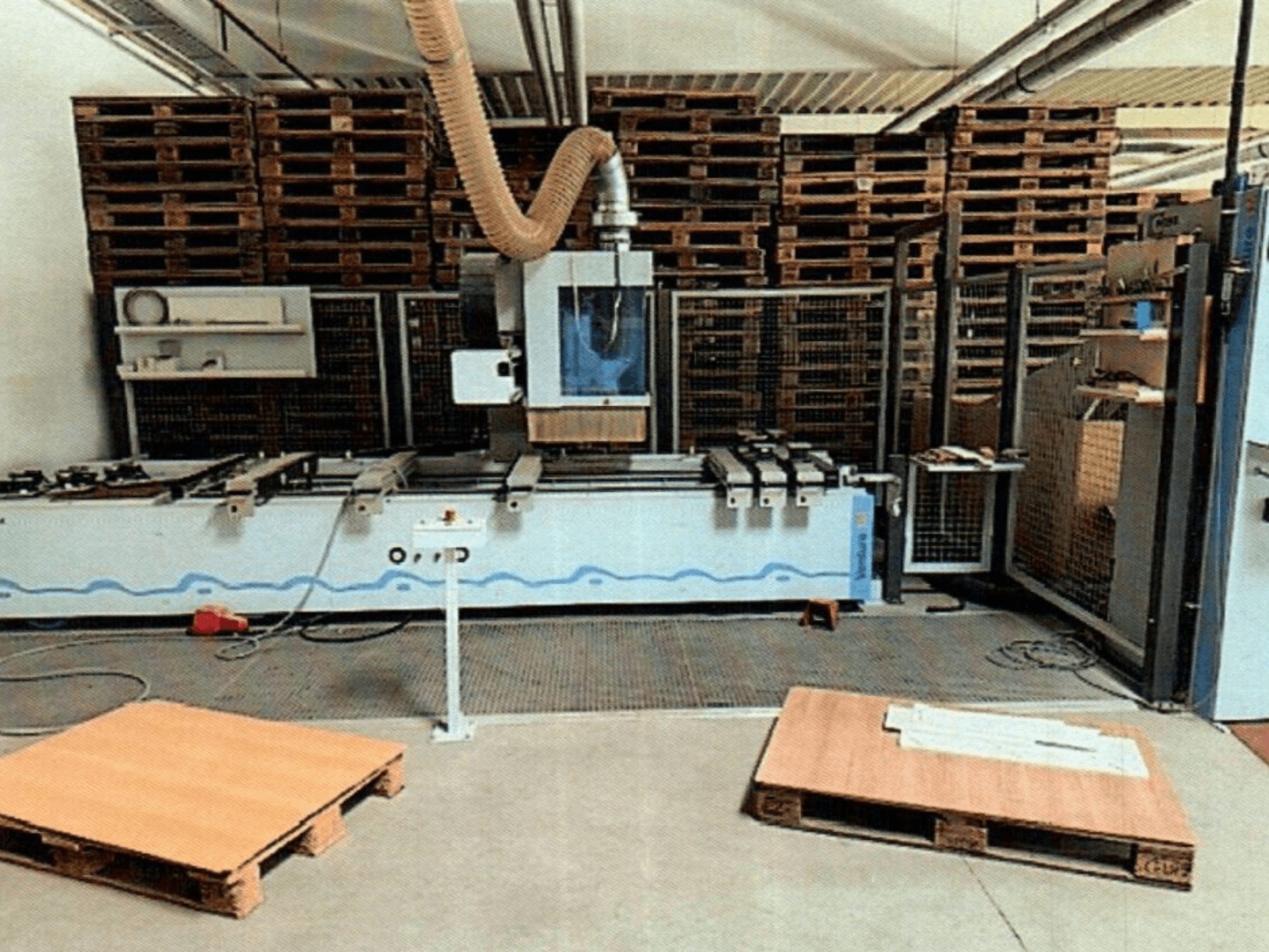 CNC houtbewerkingscentrum Weeke Venture 1M in een werkplaats, vooraanzicht met houten pallets zichtbaar en industriële opstelling.