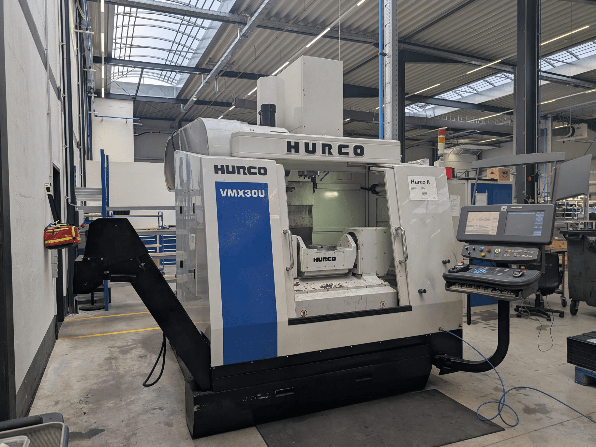 Hurco VMX30U CNC machine in een werkplaats, vooraanzicht, met bedieningspaneel met knoppen en databeeldscherm.