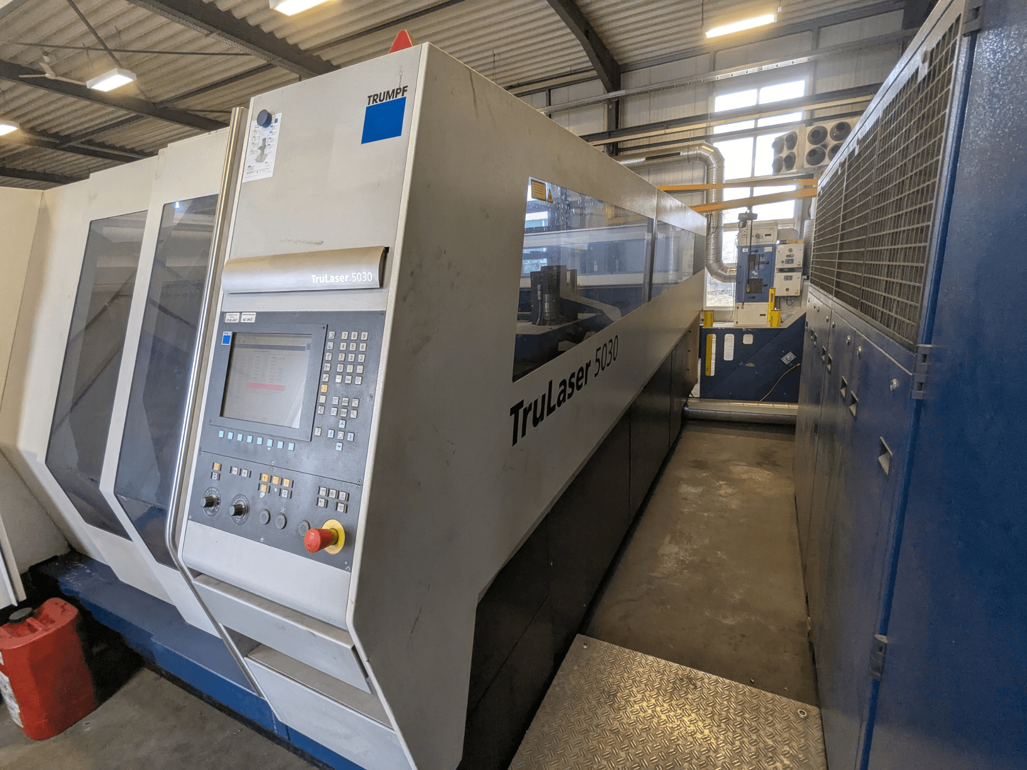 TRUMPF TruLaser 5030 CO2 lasersnijmachine, vooraanzicht met bedieningspaneel en slank ontwerp, in industriële omgeving.