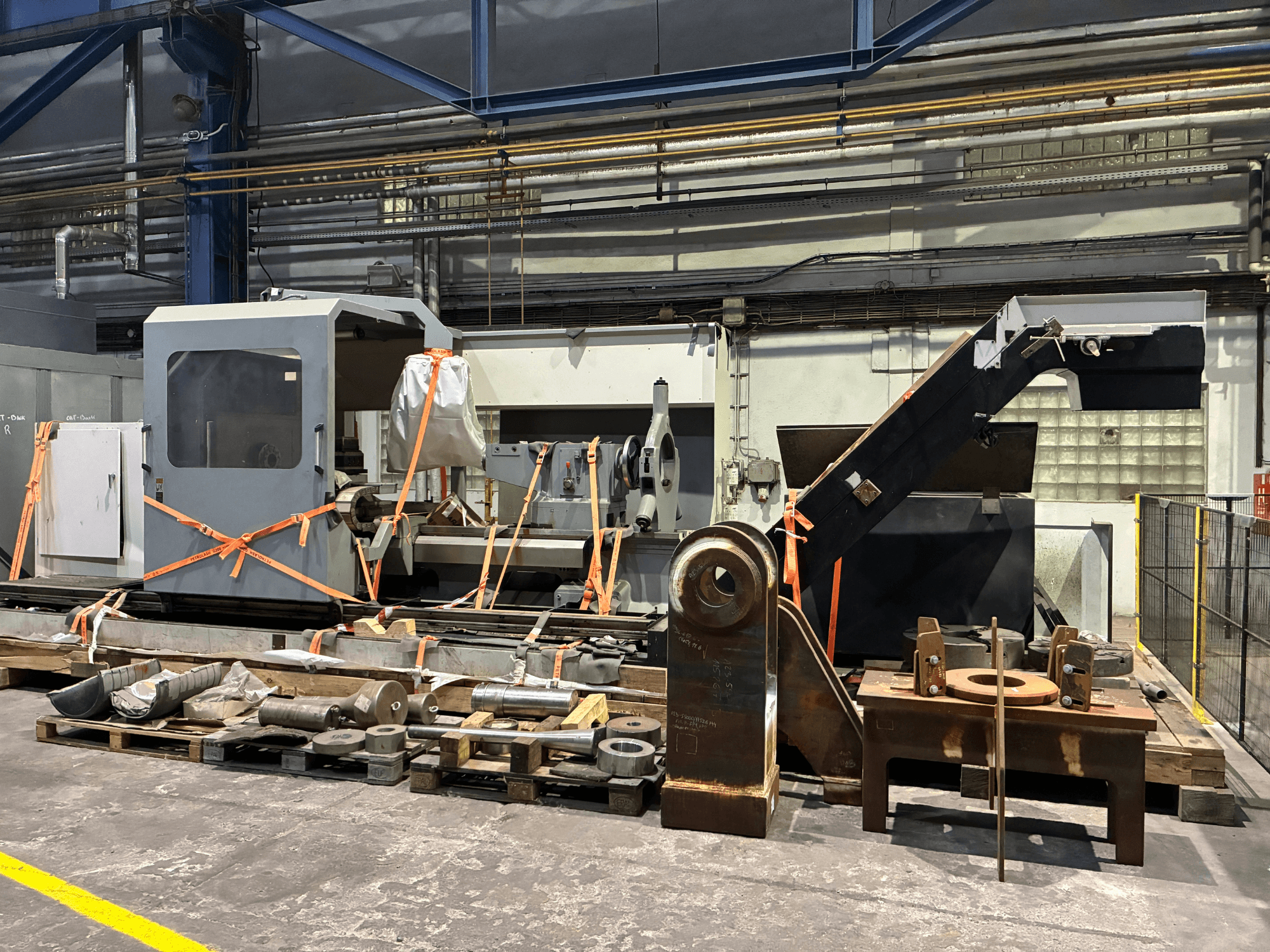 De Geminis GT5 G2-1000x2000 horizontale draaimachine, te zien in vooraanzicht, vastgezet met spanbanden en omringd door diverse apparatuur.