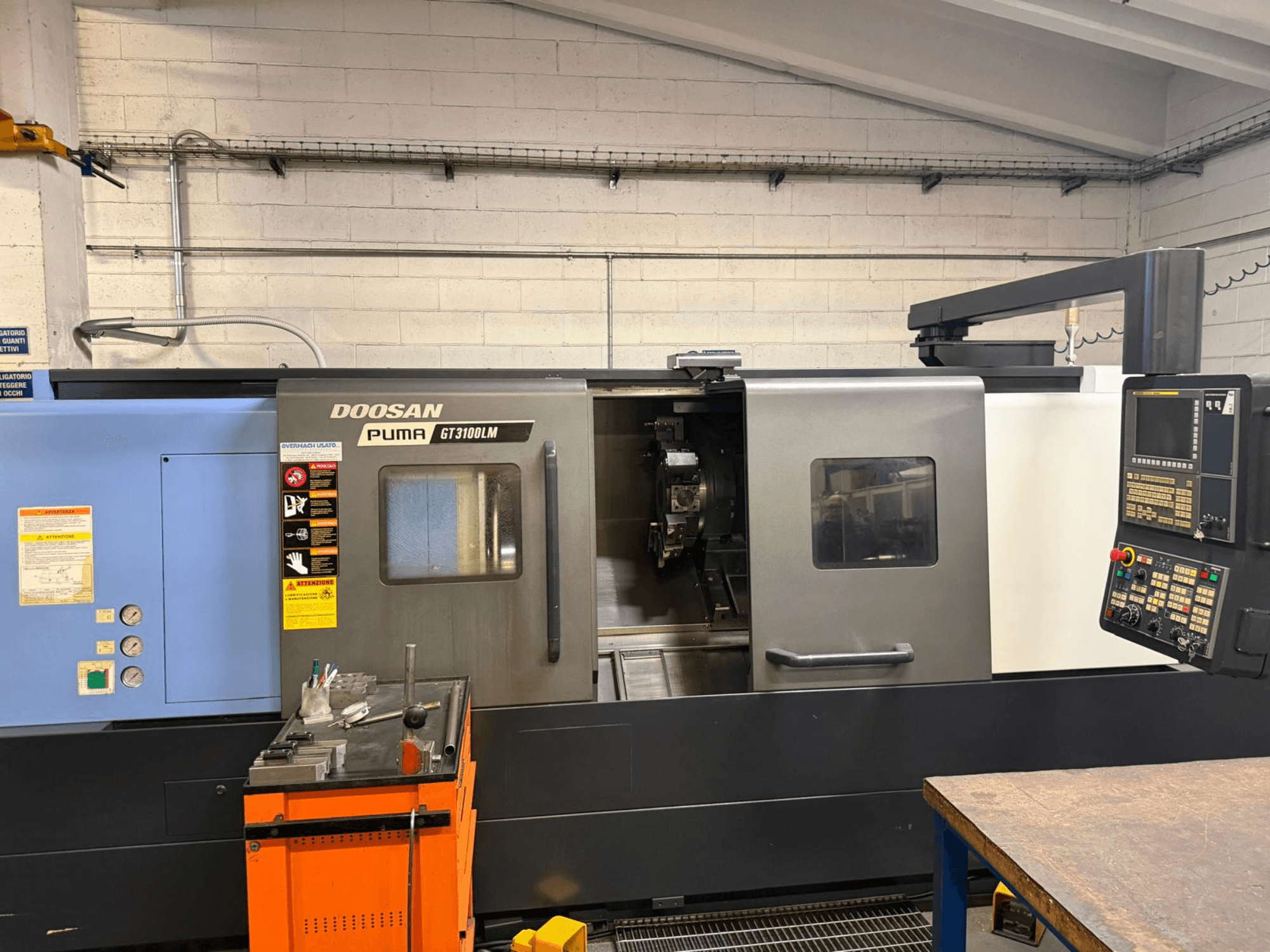 Vooraanzicht van de DOOSAN PUMA GT3100LM horizontale draaimachine, met het bedieningspaneel en het werkgebied met gereedschappen.