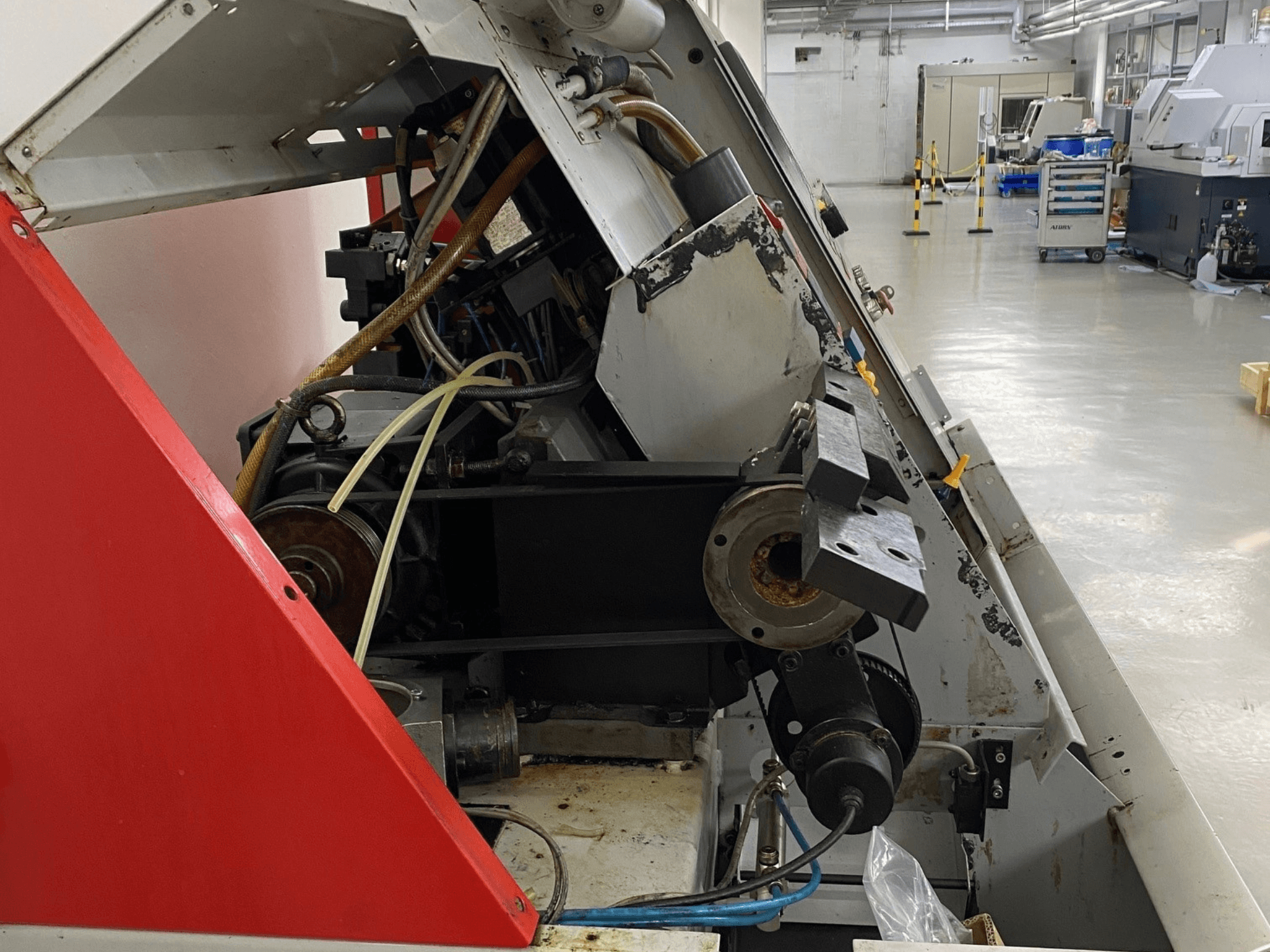 EMCO Emcoturn 325 horizontale draaimachine, zijaanzicht met aandrijfcomponenten en hydrauliek in industriële omgeving.