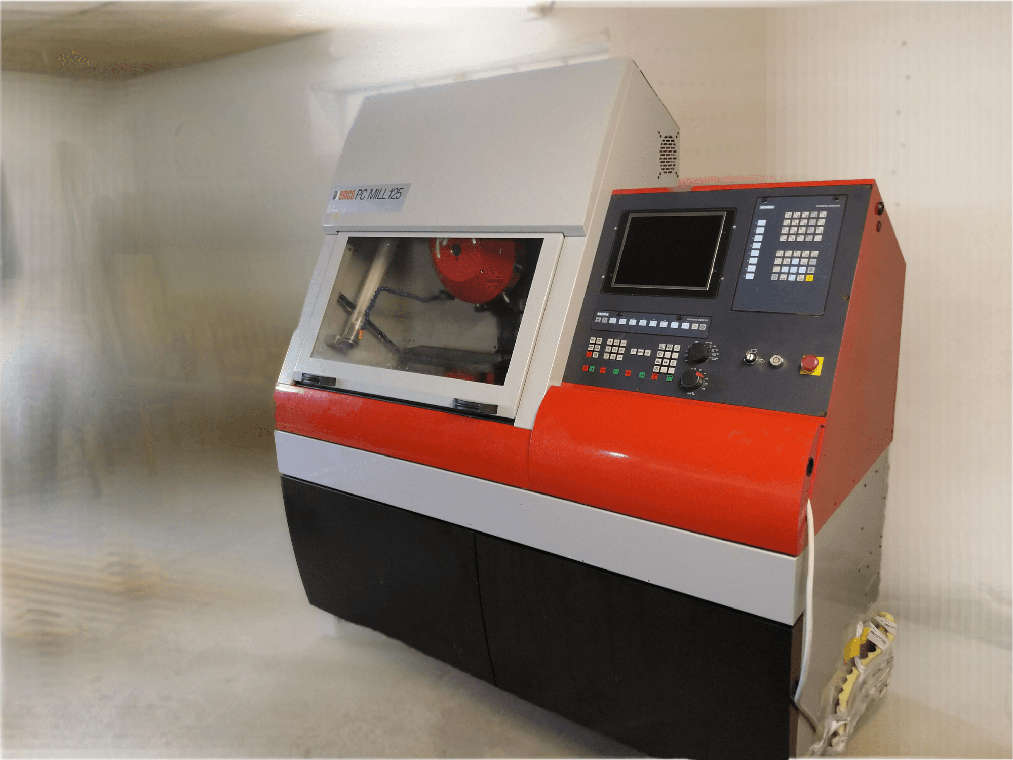 EMCO PC MILL 125 verticaal bewerkingscentrum, vooraanzicht met bedieningspaneel en zichtbaar bewerkingsgebied.