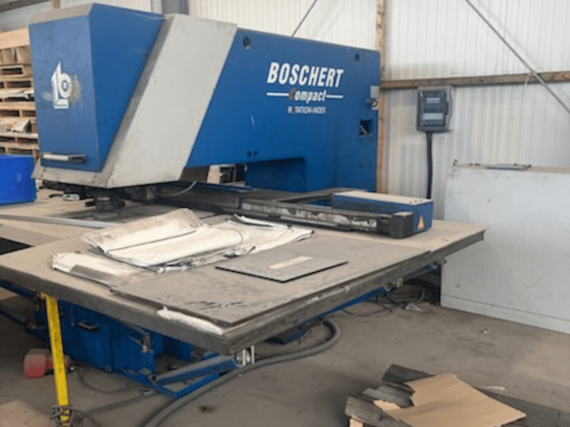 Een BOSCHERT COMPACT 1000 CNC-ponsmachine in een werkplaats, gezien vanaf de voorkant met metalen platen op de tafel.