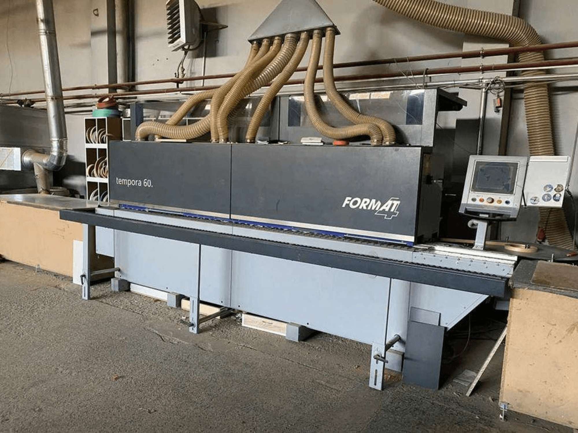 FORMAT4 Tempora 60 kantenaanlijmmachine in zijaanzicht, met meerdere slangen en een bedieningspaneel met knoppen en scherm.