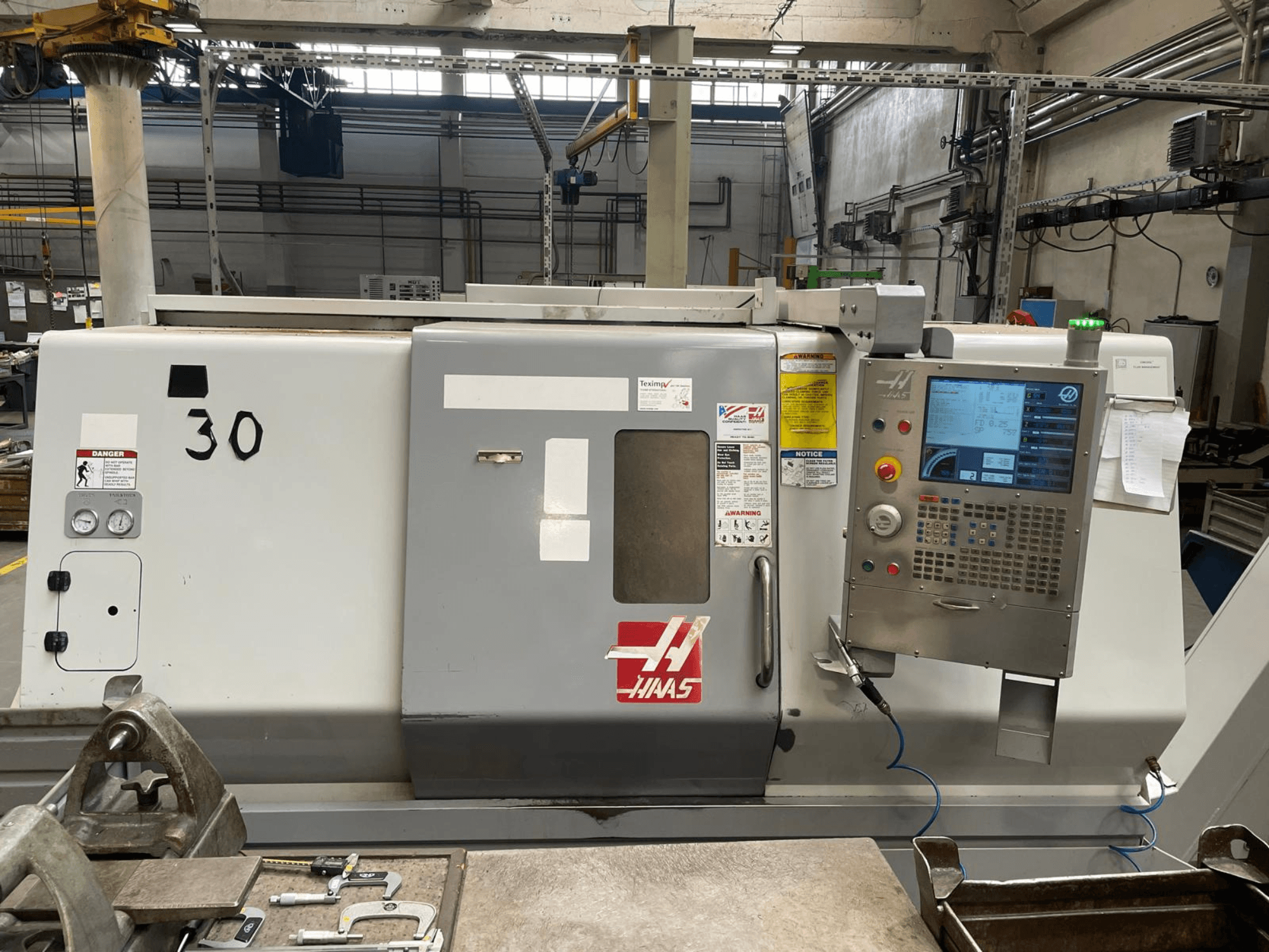 Vooraanzicht van de Haas SL-30THE horizontale draaimachine, met digitaal bedieningspaneel, waarschuwingslabels en modelnummer 30.