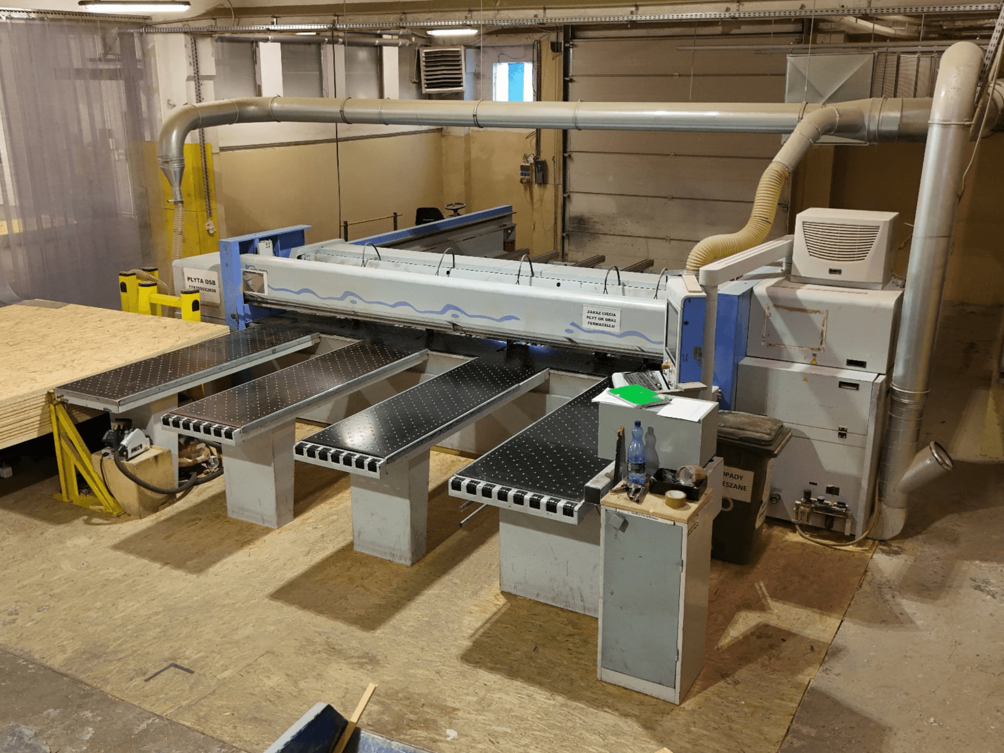HOLZMA HPP 350/43/38 paneelzaag in een werkplaats, gezien van bovenaf, met zicht op het zaaggebied en de steuntafels.