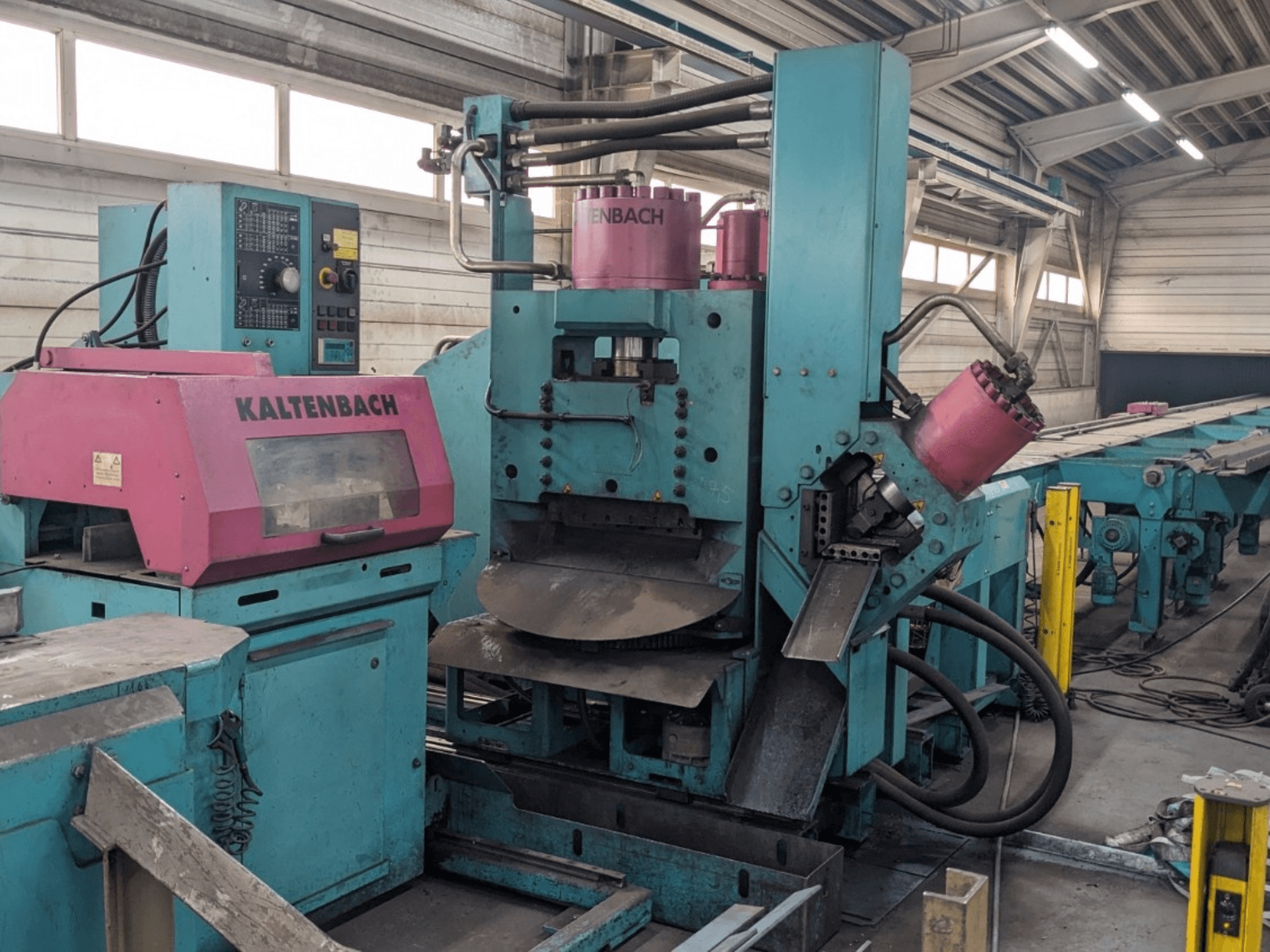 KALTENBACH industriële machine in groenblauw en roze, vooraanzicht, met bedieningspaneel en hydraulische onderdelen.